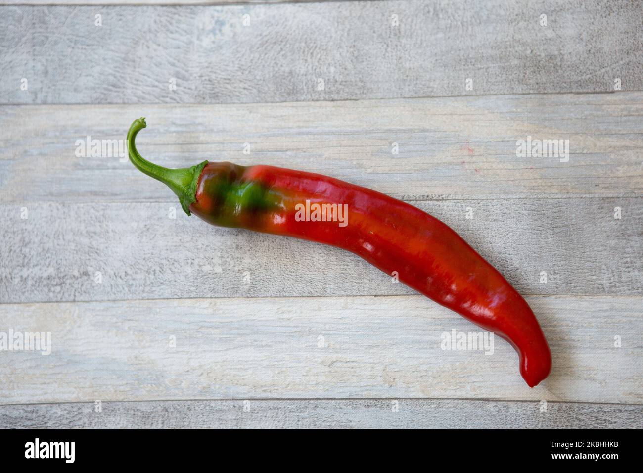 Fond de piment fort. Grains de poivre rouge sur fond de table en bois gris. Concept d'alimentation saine. Banque D'Images