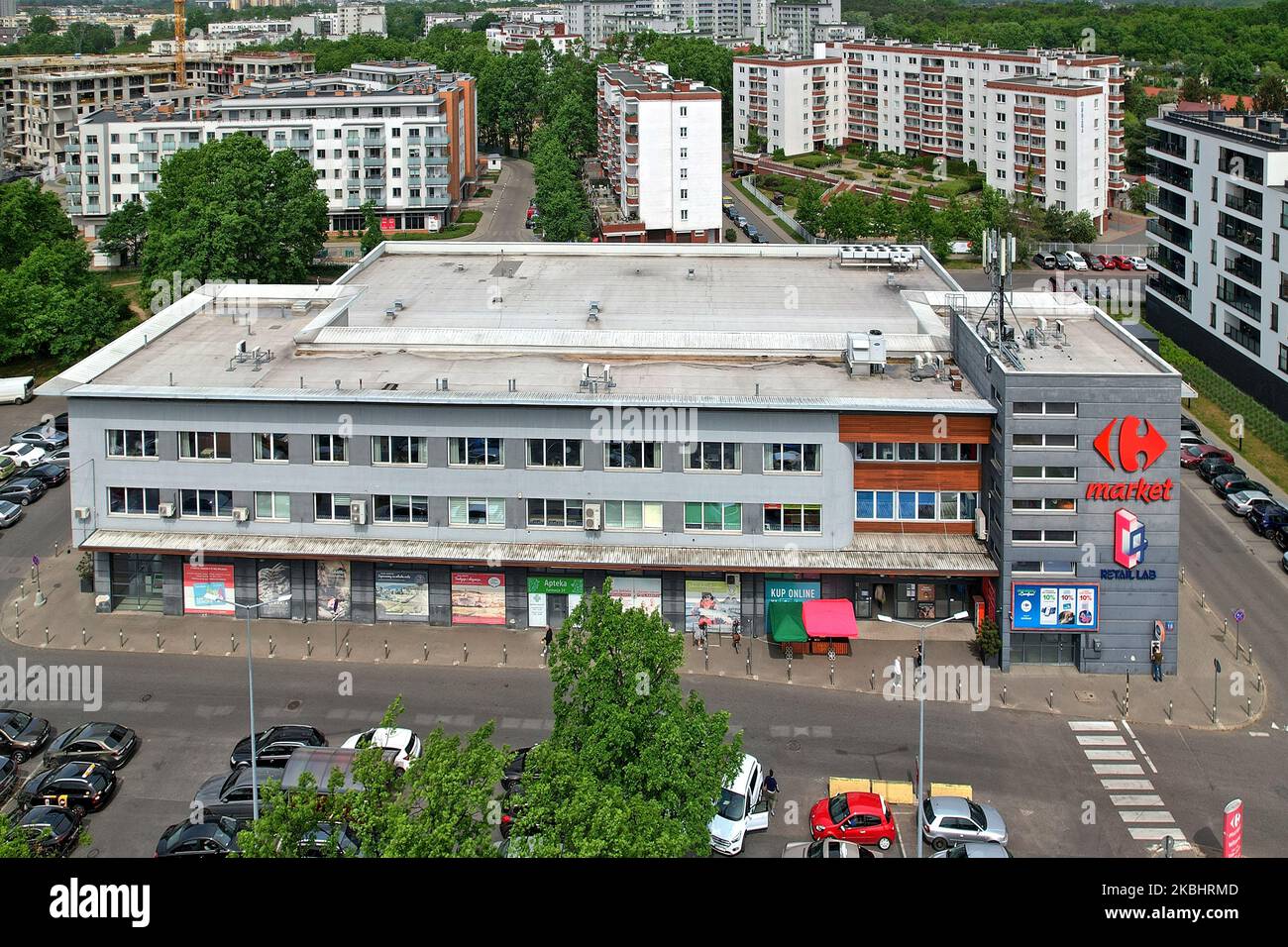 Vue aérienne du C4 Coworking Space et du Carrefour Market Building à Varsovie un jour ensoleillé, capturant la construction urbaine et l'activité commerciale Banque D'Images