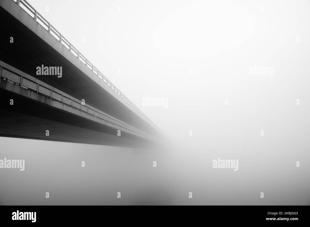 long pont sur l'eau dans le brouillard en automne Banque D'Images