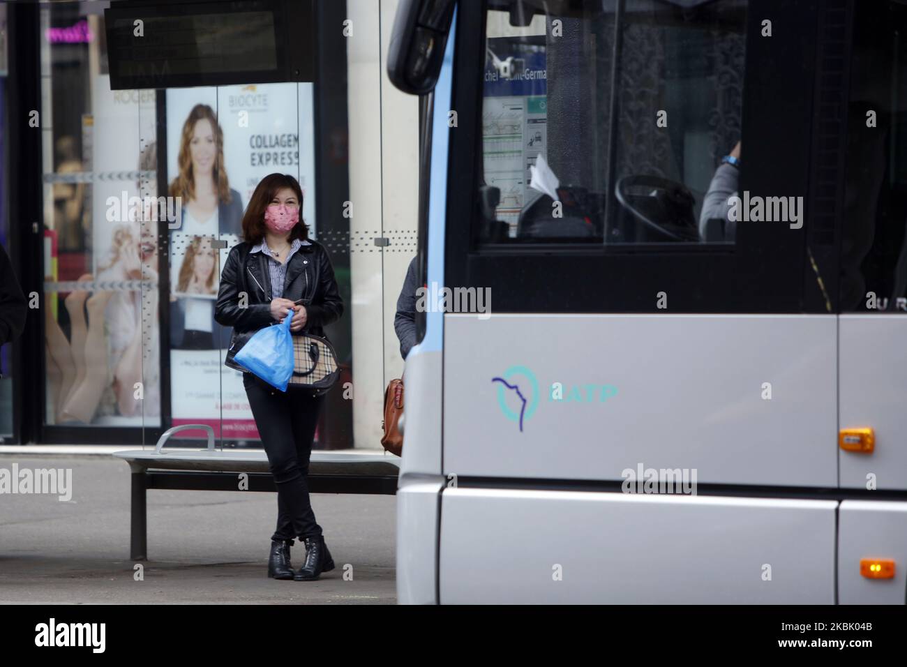 Femme portant un masque de protection vu entrer dans un bus à Paris, France sur 14 mars 2020. La RATP et la SNCF ont annoncé qu'elle offrirait une offre de transport réduite afin de ralentir la dynamique de l'épidémie. (Photo de Mehdi Taamallah/NurPhoto) Banque D'Images