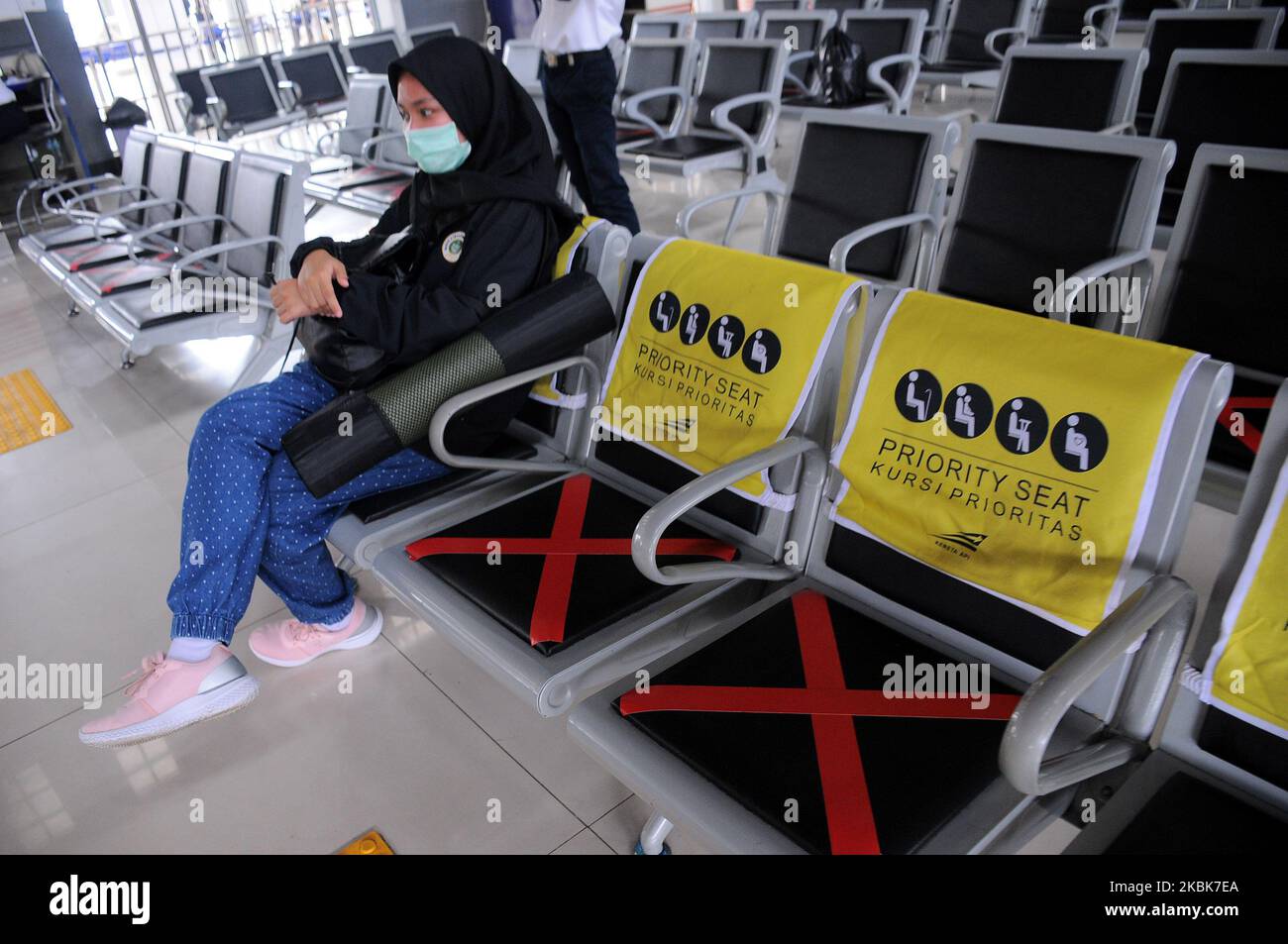Les responsables des trains mettent des autocollants en croix sur les chaises d'attente à la gare de Pasar Senen, Jakarta, Le 19,2020 mars, l'activité consiste à fournir un panneau limitant aux utilisateurs de chemins de fer afin de pouvoir garder leur distance des autres passagers dans un effort de mettre en œuvre des appels de distanciation sociale pour empêcher la propagation du virus corona (covid-19) et de vérifier la température corporelle des passagers potentiels Dans le quartier de la gare de Pasar Senen. (Photo de Dasril Roszandi/NurPhoto) Banque D'Images