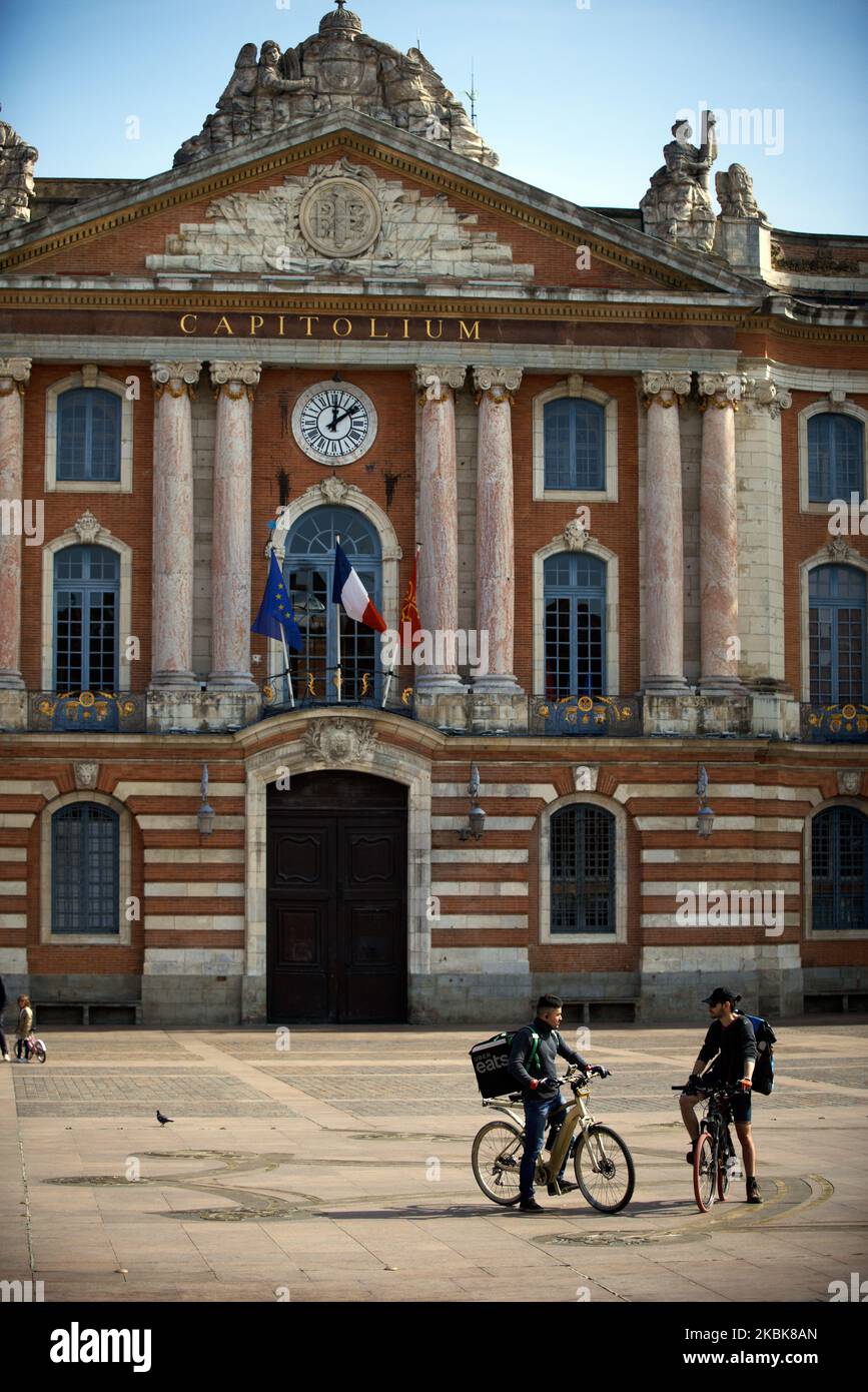 Deux liveurs discutent au centre de la place la plus emblématique et touristique de Toulouse, en France, sur 19 mars 2020 qui est vide. Pour les 3rd jours, les Français sont en confinement. Depuis mars 16T, lorsque le président français Macron a annoncé que toutes les personnes seraient en isolement cellulaire en raison de la pandémie du coronavirus Covid-19, tous les magasins « non essentiels » sont fermés jusqu'à nouvel ordre. La police patrouille dans les rues pour vérifier les personnes à l'extérieur. Les gens doivent avoir un permis pour se déplacer. Seules les pharmacies, les magasins d'alimentation et les magasins de tabac peuvent ouvrir. (Photo d'Alain Pitton/NurPhoto) Banque D'Images