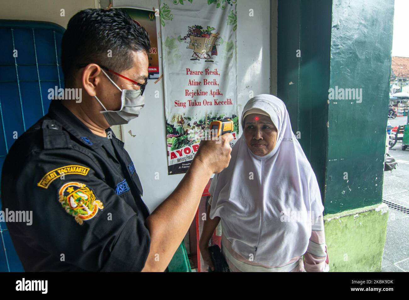 Un fonctionnaire vérifie la température corporelle des visiteurs avant d'entrer sur un marché traditionnel à Yogyakarta, en Indonésie, sur 20 mars 2020, en raison des préoccupations de l'épidémie de coronavirus COVID-19. Le gouvernement indonésien a recommandé que les gens se distancer des autres pour ralentir la propagation de la maladie du nouveau coronavirus COVID-19. L'Indonésie a confirmé 32 décès, 369 cas positifs et 17 cas de coronavirus. (Photo de Rizqullah Hamiid/NurPhoto) Banque D'Images