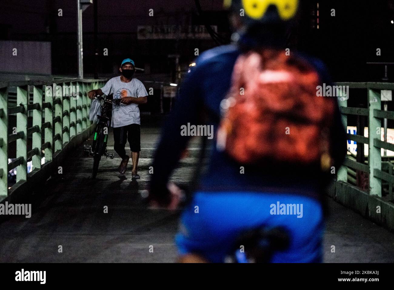 Un homme tenant un vélo passe par un passage pour piétons à Quezon City, Philippines, sur 20 mars 2020. L'île de Luzon, y compris le métro de Manille, est placée sous une quarantaine communautaire renforcée dans le but de freiner la propagation de la COVID-19. Les classes, le travail et le transport de masse sont suspendus sur toute l'île avec quelques exemptions. Le mouvement des personnes se limite à l'accès aux nécessités de base.(photo de Lisa Marie David/NurPhoto) Banque D'Images
