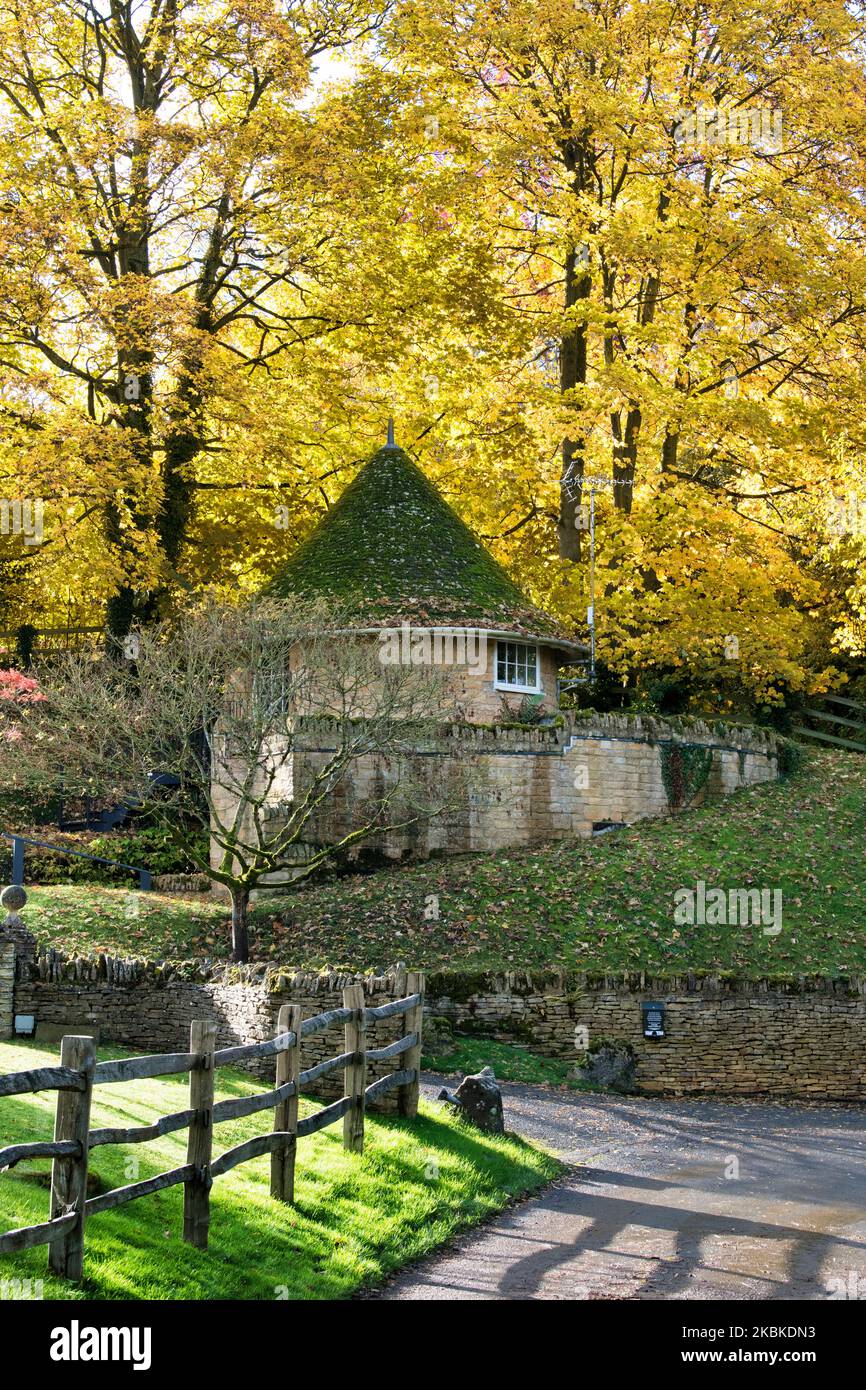 Arbres d'automne et maison ronde. Buckland, Gloucestershire, Cotswolds, Angleterre Banque D'Images