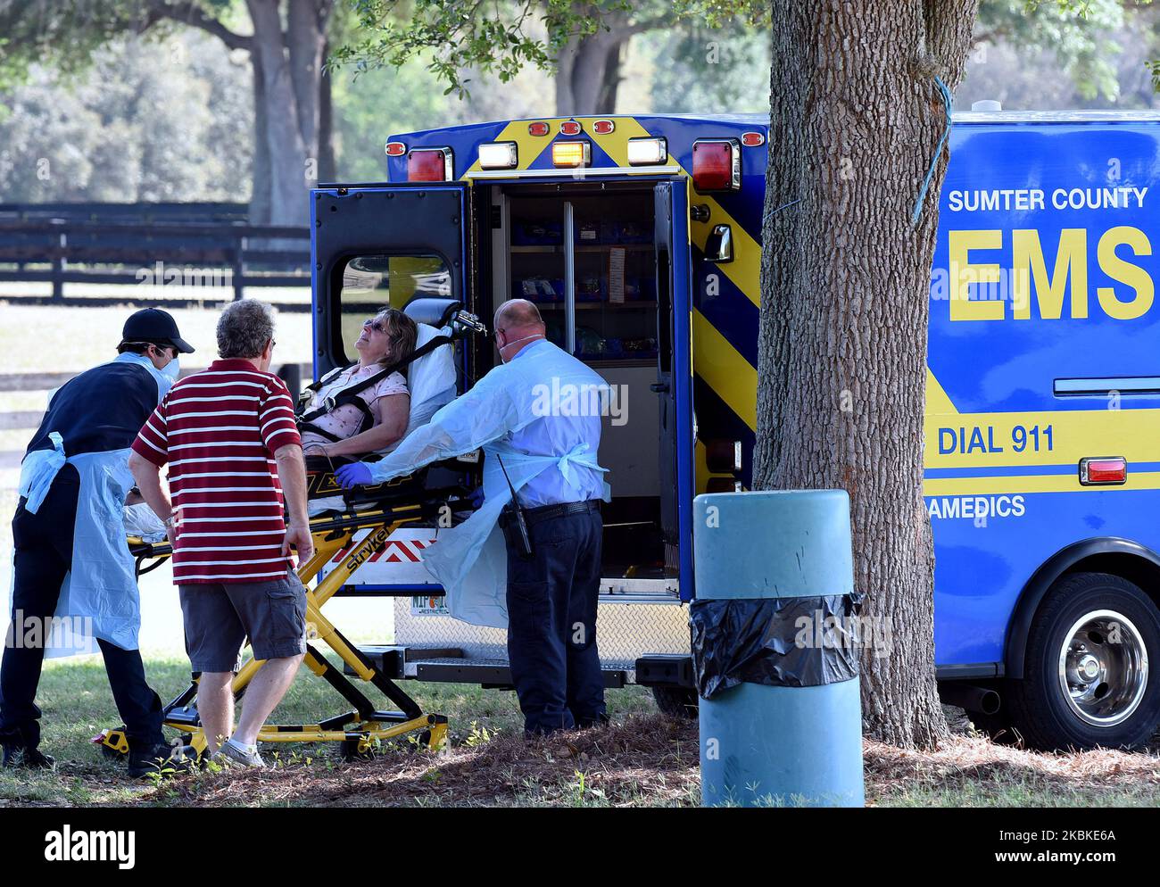 Une femme est placée dans une ambulance par des ambulanciers paramédicaux après être arrivée dans une voiture à un site d'essai mobile COVID-19 au club de polo des villages de 23 mars 2020 dans les villages, en Floride. Les travailleurs de la santé de cette communauté de retraite feront du personnel sur le site d'essai pendant les cinq prochains jours. (Photo de Paul Hennessy/NurPhoto) Banque D'Images