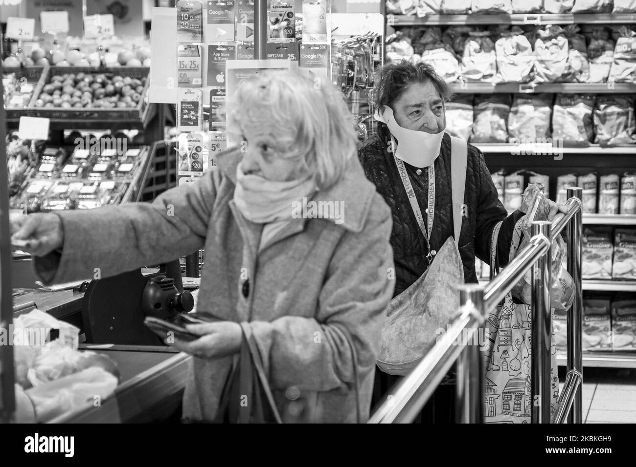(NOTE DE LA RÉDACTION: L'image a été convertie en noir et blanc) les femmes âgées portant un masque facial de protection achètent des marchandises dans un magasin dans le centre de Padoue, en Italie, sur 25 mars 2020. (Photo de Roberto Silvino/NurPhoto) Banque D'Images