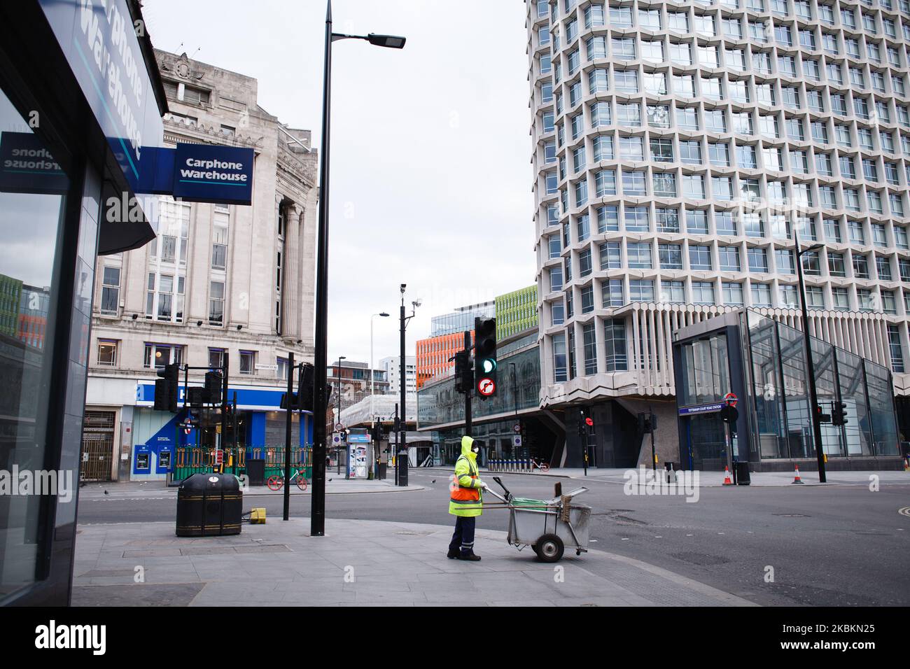 Un balai de rue portant un masque s'arrête à un croisement à la jonction déserte de Tottenham court Road et Oxford Street à Londres, en Angleterre, sur 28 mars 2020. Le Royaume-Uni a entamé aujourd'hui son premier week-end dans le cadre des conditions de confinement du coronavirus Covid-19 imposées lundi soir par le Premier ministre britannique Boris Johnson, dans le cadre duquel les gens peuvent quitter leur foyer uniquement pour acheter des articles essentiels, faire de l'exercice, fournir des soins et, si nécessaire, se rendre au travail et en sortir. Au Royaume-Uni, le nombre de décès s'est élevé à 1 019, après que 260 autres personnes aient perdu la vie au cours des 24 dernières heures. (Photo de David Cliff/NurPhoto) Banque D'Images