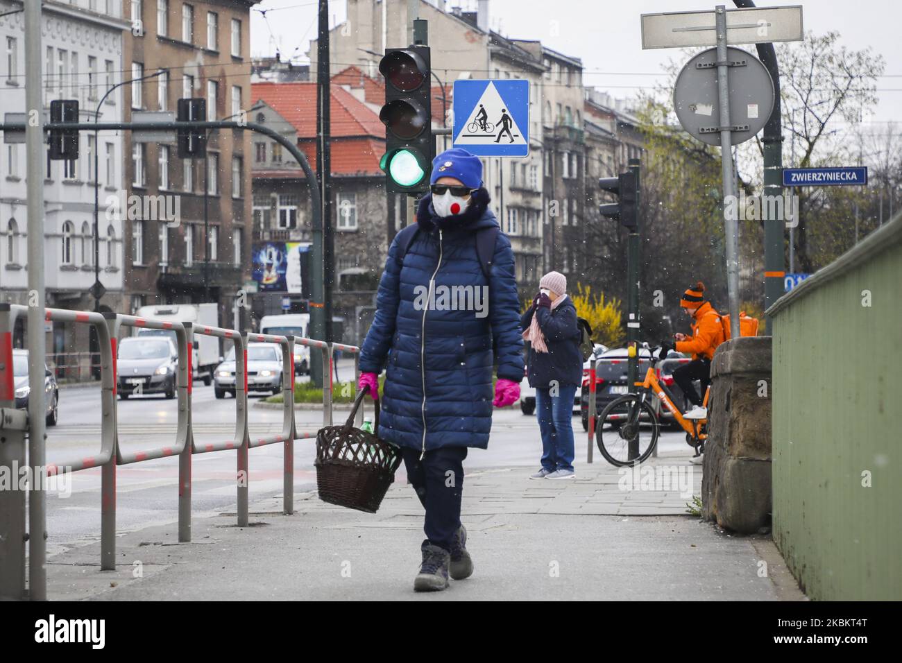 Une femme portant un masque facial protecteur en raison de la propagation du coronavirus marche avec des fournitures à Cracovie, en Pologne, sur 31 mars 2020. Le gouvernement polonais a introduit de nouvelles restrictions strictes pour lutter contre les infections à COVID-19, comme empêcher de quitter la maison à moins que cela ne soit justifié, interdire aux enfants de moins de 18 ans de quitter la maison à moins d'être surveillés par un adulte, fermer des parcs et des plages et ordonner la fermeture de la plupart des hôtels. (Photo de Beata Zawrzel/NurPhoto) Banque D'Images