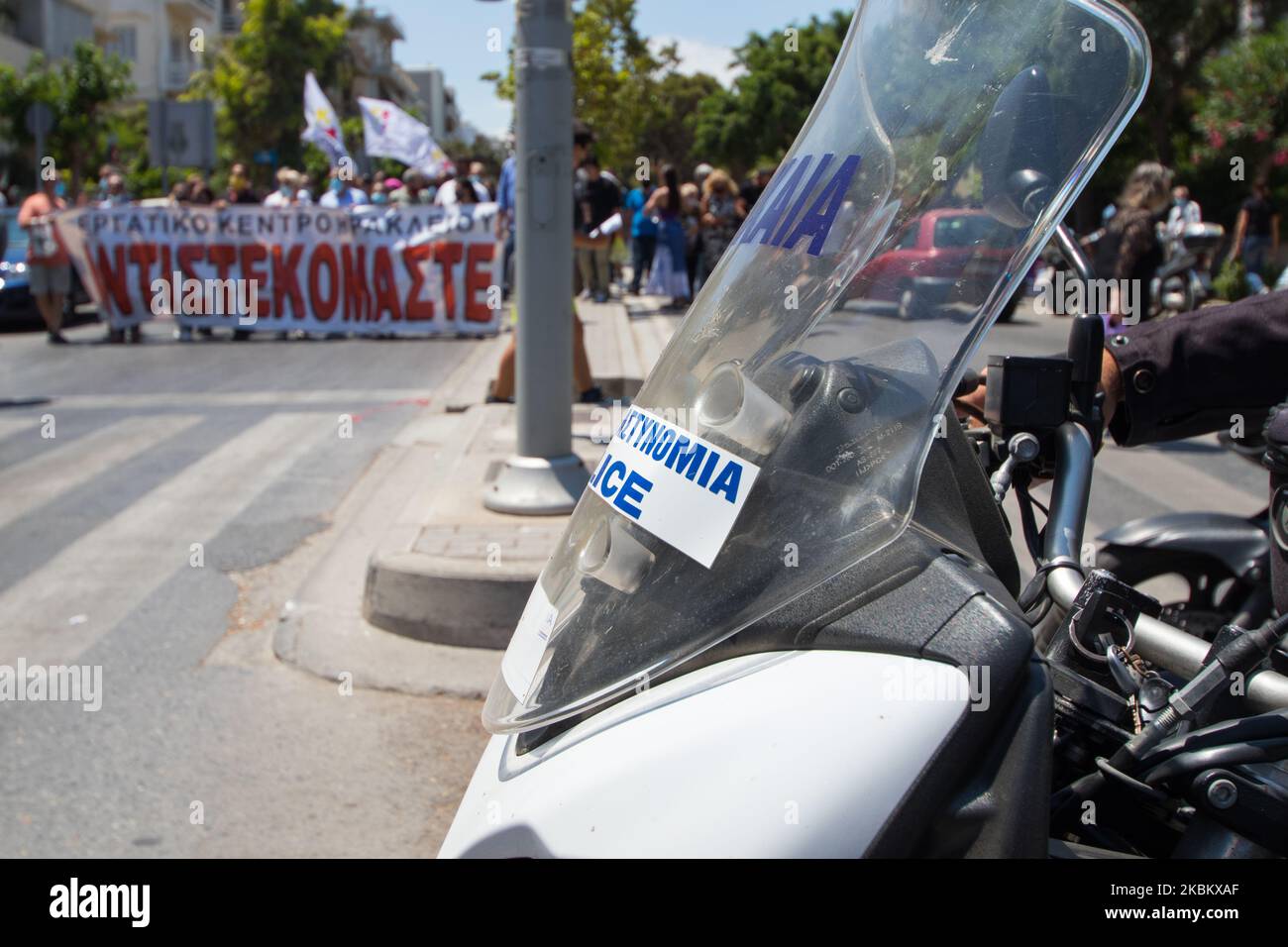 Des manifestants en grève générale en Grèce, contre les réformes du travail du gouvernement. Gros plan d'une moto de police. Des manifestants en arrière-plan défilent. Banque D'Images