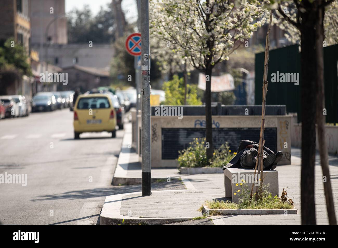 Une personne peut dormir sur un banc en plein jour. En arrière-plan, une route normalement fréquentée qui, en raison du confinement, semble déserte sur 7 avril 2020 à Rome. Le gouvernement italien a émis des mesures de confinement à l'échelle nationale pour aider à stopper la propagation de la COVID-19 (photo d'Andrea Pirri/NurPhoto) Banque D'Images