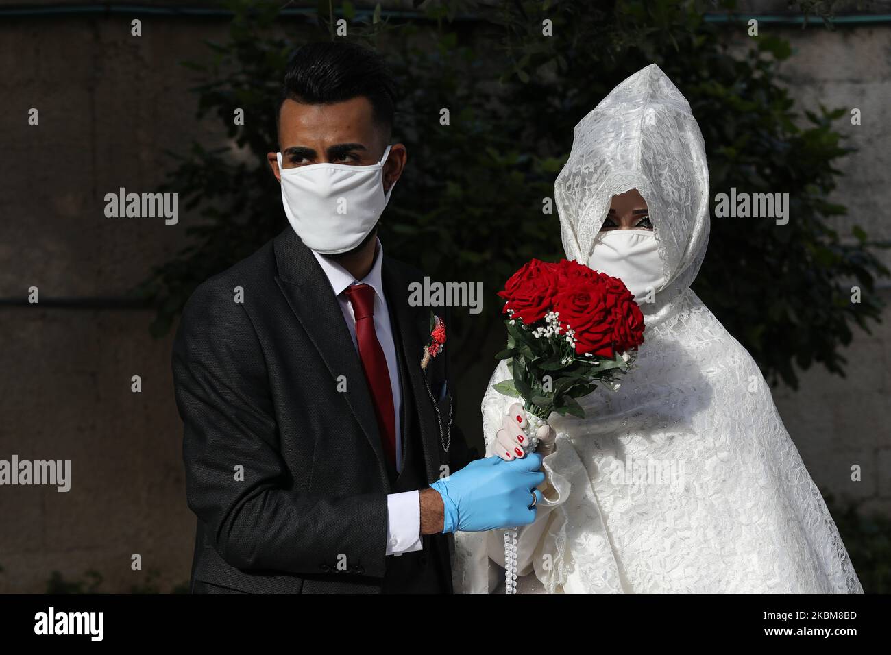 Le marié palestinien Ali Abu Saif et sa mariée Nermin portent des masques au milieu de l'épidémie de COVID-19, lors d'un séance photo avant leur cérémonie de mariage à Gaza, sur 10 avril 2020. (Photo de Majdi Fathi/NurPhoto) Banque D'Images