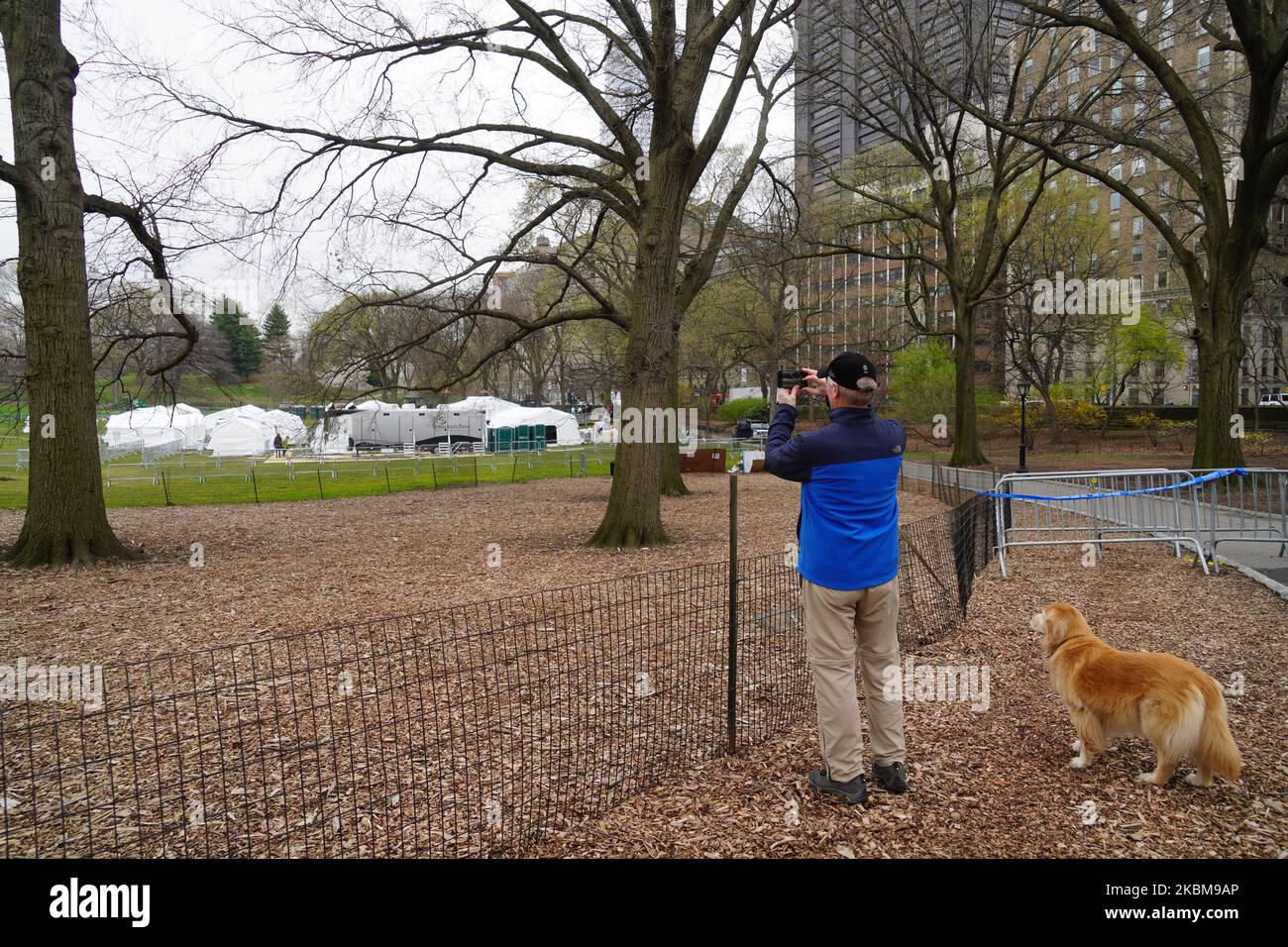 Un homme avec son chien est vu à côté de l'hôpital de campagne construit par Samaritan's Pulse à Central Park sur 30 mars 2020, pour traiter les patients atteints de coronavirus de débordement des hôpitaux du Mont Sinaï. (Photo de Selcuk Acar/NurPhoto) Banque D'Images