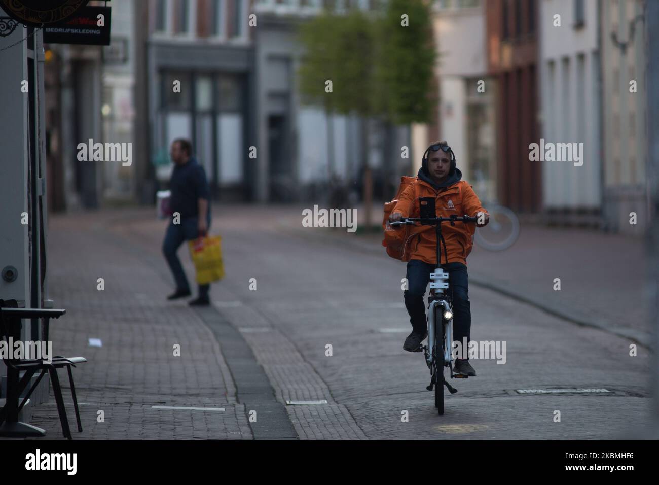 Un livreboy fait son vélo pendant la pandémie du coronavirus. Le gouvernement néerlandais a ordonné la fermeture des installations publiques et a conseillé aux gens de rester chez eux pour tenter de contrôler la propagation du coronavirus COVID-19. (Photo de Federico Guerra Moran/NurPhoto) Banque D'Images
