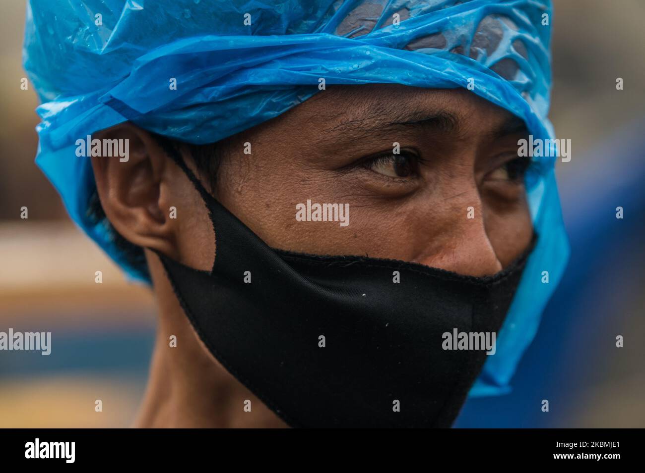 Un homme portant un masque facial de protection couvre sa tête avec un plastique dans une zone de taudis à Tondo, Manille aux Philippines sur 18 avril 2020. Environ 500 familles ont perdu leur maison après un incendie dans la région. Manille et l'ensemble de l'île de Luzon restent en quarantaine communautaire renforcée. Le nombre de cas confirmés de COVID-19 dans le pays dépasse 6 000.(photo de Lisa Marie David/NurPhoto) Banque D'Images