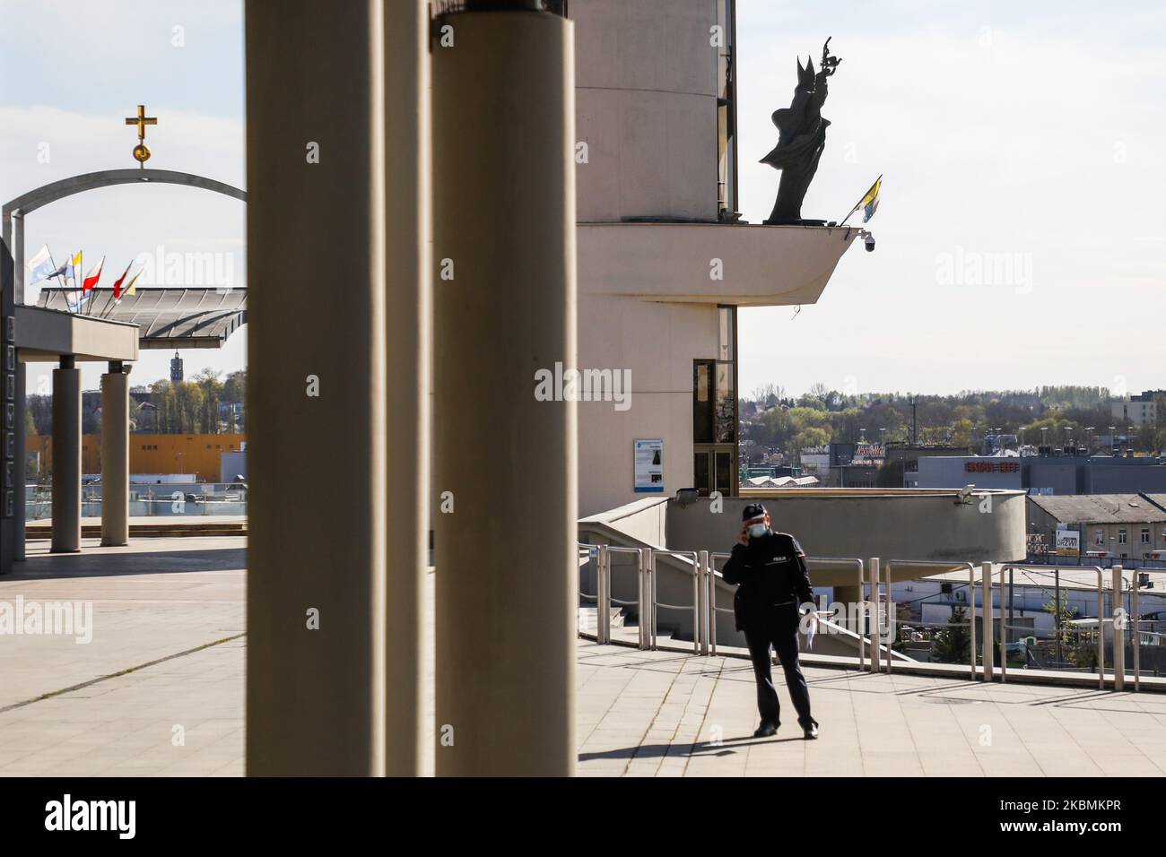 Un policier sous sa surveillance pendant la Fête de la Miséricorde au Sanctuaire de la Divine Miséricorde à Lagiewniki pendant la propagation du coronavirus. Cracovie, Pologne, le 19 avril 2020. La fête de la Divine Miséricorde établie par le pape Jean-Paul II est célébrée le premier dimanche après Pâques, et cette date voit l'apogée annuelle des pèlerinages au sanctuaire. En raison de la pandémie du coronavirus et selon l'ordonnance des autorités de l'État et de l'église, un maximum de cinq personnes peuvent assister à la messe et aux services dans l'église. Les participants à la messe doivent attendre dans une ligne, en gardant une distance de sécurité, si Th Banque D'Images