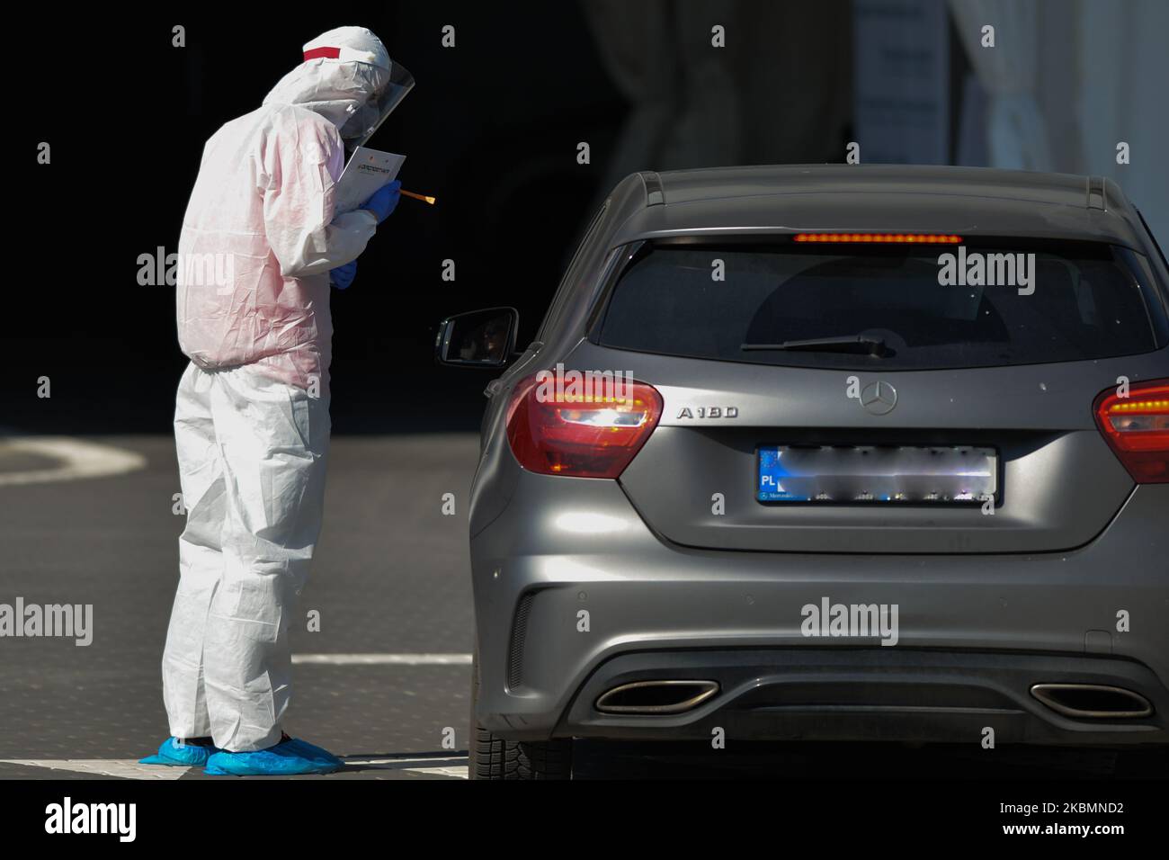 (NOTE DE LA RÉDACTION : la plaque de voiture a été brouillée) le travailleur de Diagnostics Medical Laboratories effectue un écouvillon pour recueillir un échantillon pour le test du coronavirus au centre de test de Taurion Arena à Cracovie. La société privée facture 584 zloty polonais (environ 130 euros) pour le test. Le nombre d'infectés par le virus continue de croître en Pologne et le ministère de la Santé a signalé aujourd'hui 263 nouveaux cas et 21 décès, avant 5pm, ce qui porte le nombre total à 9 865 personnes infectées, 401 décès et 1 297 cas de rétablissement. Mardi, 21 avril 2020, à Cracovie, en Pologne. (Photo par Artur Widak/NurPhoto) Banque D'Images