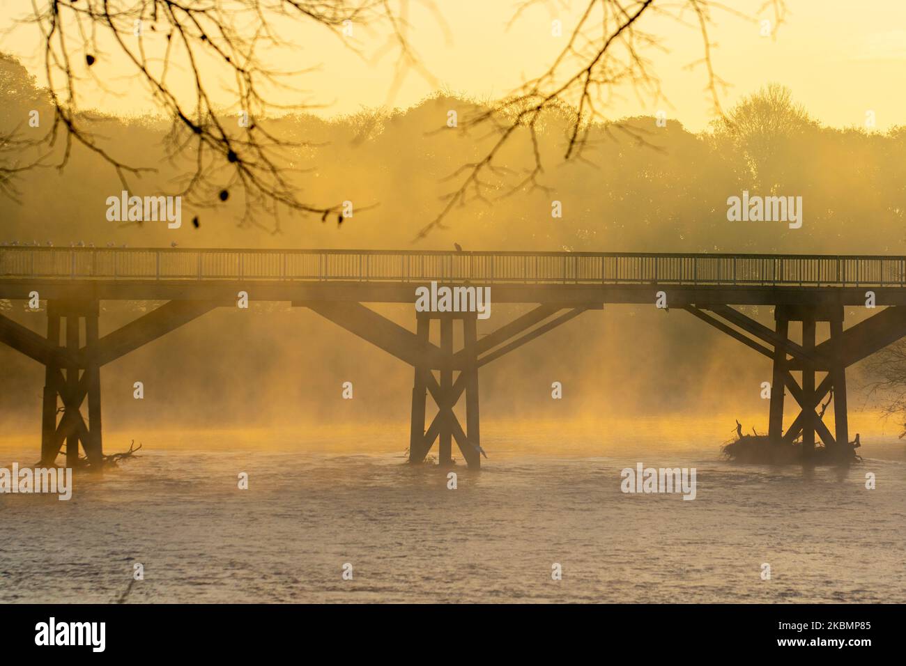 L'ancien pont de tram dans le parc Avenham de Preston, Lancashire. Météo Royaume-Uni 4 novembre 2022. Une matinée froide et brumeuse au coucher du soleil sur le Ribble et les résidents locaux s'exercent le long de la promenade au bord de la rivière dans Avenham Park. Des périodes ensoleillées sont prévues après le premier gel de l'automne. Crédit; MediaWorldImages/AlamyLiveNews Banque D'Images