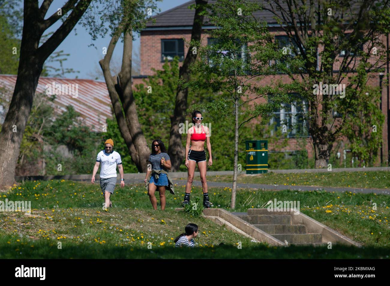 Une femme en lunettes de soleil et rollerblades garde socialement distancé et profite du soleil à Peel Park, Salford, Greater Manchester, le samedi 25th avril 2020. (Photo de Pat Scaasi/MI News/NurPhoto) Banque D'Images