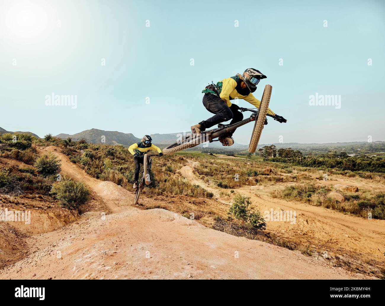 Vélo de montagne, saut sportif extrême et piste de terre extérieure pour les amis sur le vélo aventure dans la nature. Vélo en équipe, montagne de rochers et Banque D'Images