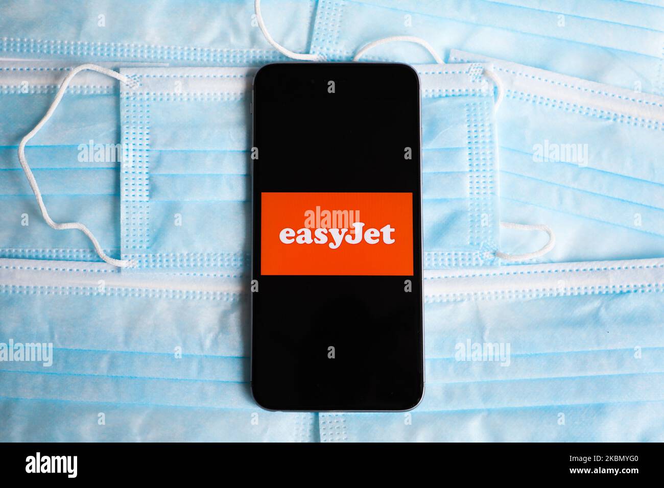 Le logo easyJet est affiché sur un écran de téléphone mobile photographié sur un fond de masque chirurgical pour une photo d'illustration pendant la propagation du coronavirus. Cracovie, Pologne sur 26 avril 2020. (Photo Illustration par Beata Zawrzel/NurPhoto) Banque D'Images