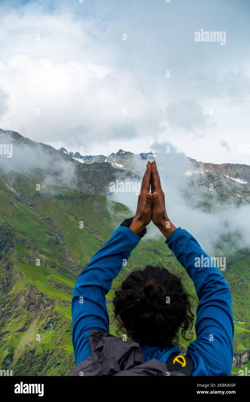 14 juillet 2022, Himachal Pradesh Inde. Un homme tenant une posture de Namaste au-dessus de la tête avec les mains pliées vers le pic Shrikhet Mahadev, le Shivling, un symbo Banque D'Images