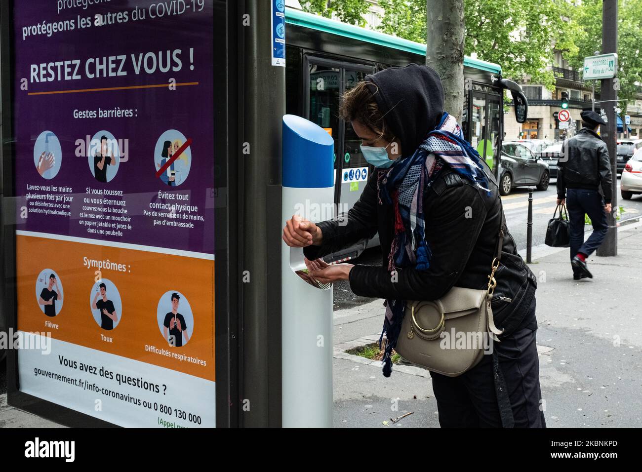 Une jeune femme se lave les mains avec du gel hydroalcoolique à partir d'un distributeur de gel installé à l'arrêt d'autobus de la RATP le lundi 11 mai 2020 à Paris, le premier jour de la levée du verrouillage de la population française causé par la pandémie de coronavirus COVID-19 qui a duré 55 jours. Les Parisiens retournent dans les rues et dans les transports publics avec l'assouplissement des mesures de distanciation sociale et la réouverture de certains magasins. (Photo de Samuel Boivin/NurPhoto) Banque D'Images
