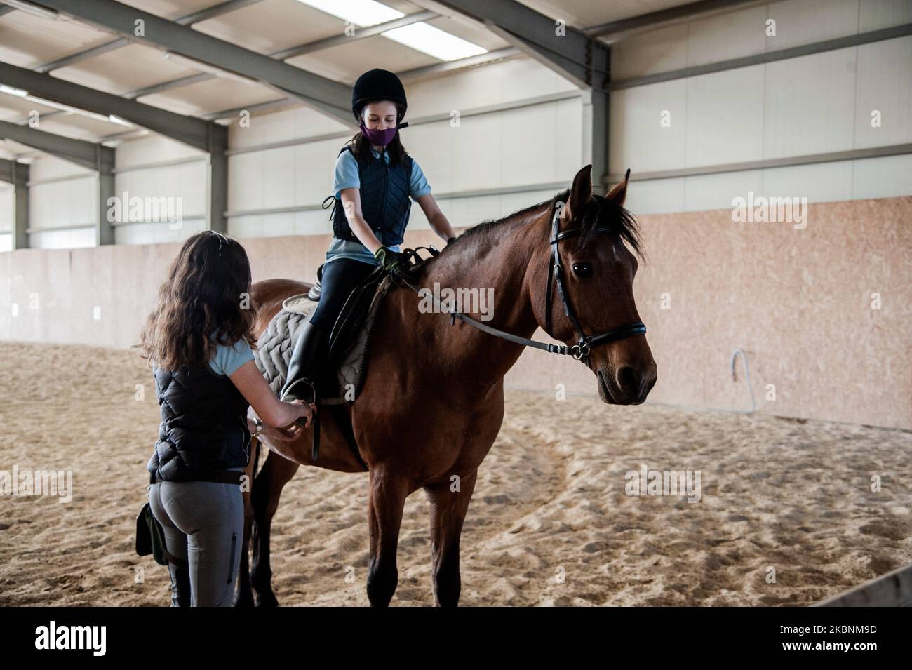 Little Emilia reçoit des leçons avant de monter de son professeur Maria NESTOROVA. Club de cheval de Kichevo, Varna, Bulgarie r?sume cours d'équitation pour leurs clients. Le gouvernement bulgare a assoupli les mesures liées à la non-prolifération de la COVID-19, permettant des promenades dans les parcs et certains sports. Bien entendu, la formation est réalisée dans le cadre de mesures de désinfection améliorées. Les cafés et les restaurants peuvent avoir des clients, mais la distance entre les tables doit être de 1,5 mètres et les serveurs doivent porter des masques de protection. Pour les clubs de sport, les règles sont - souvent la désinfection des lieux et des visages, en gardant d Banque D'Images