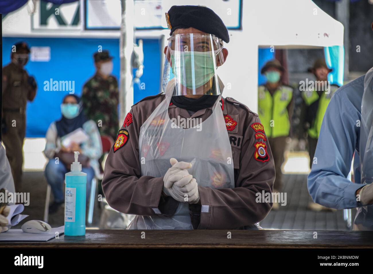 Un policier porte un masque de protection et un écran facial lors du test de diagnostic rapide du coronavirus COVID-19 (TDR) auprès du public, en raison des inquiétudes soulevées par l'éclosion du coronavirus COVID-19 à Sleman, Yogyakarta, en Indonésie, au 12 mai 2020. Le gouvernement de Sleman a procédé à un test rapide de masse auprès de personnes qui ont visité l'hypermarché d'Indogrosir au cours de la période 19 avril à 4 mai 2020, suite à un cas positif de COVID-19 dans l'hypermarché. Jusqu'à présent, l'Indonésie a confirmé 1,007 décès, 14,749 cas positifs et 3,063 cas de coronavirus récupérés. (Photo de Rizqullah Hamiid/NurPhoto) Banque D'Images