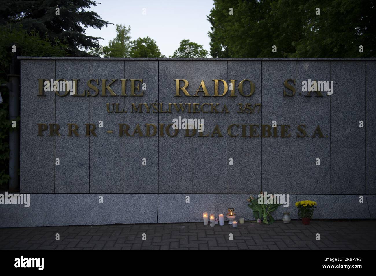 Des fleurs et des bougies allumées sont visibles sous le logo de la radio polonaise à Varsovie, en Pologne, sur 22 mai 2020. Les gens ont protesté devant la radio polonaise 3 contre la censure qui a eu lieu après qu'une chanson, libérée par le leader du groupe Kult Kazik Staszewski, a été retirée du tableau influent du vendredi. La chanson de Kaziks 'Twoj bol jest lepszy niz moj' (votre douleur est meilleure que ma douleur) est considérée comme une critique de Jaroslaw Kaczynski, chef du parti au pouvoir droit et Justice (PiS) même si son nom n'apparaît pas dans les paroles de la chanson. Kazik a écrit la chanson après la comparution de Kaczynski au moment de la commémoration Banque D'Images