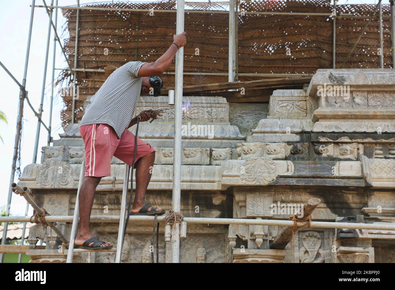 L'ouvrier sourit un échafaudage lors de la reconstruction de la tour Raja Gopuram du temple hindou Arul Eswari Muhumariamman à Jaffna, au Sri Lanka, sur 15 août 2017. La tour a été détruite par des bombardements au cours de la guerre civile de 26 ans entre l'armée sri-lankaise et les LTTE (Tigres de libération de l'Eelam tamoul). Ce n'est qu'un des nombreux rappels des cicatrices profondes laissées par la guerre civile qui a tué environ 40 000 personnes. (Photo de Creative Touch Imaging Ltd./NurPhoto) Banque D'Images