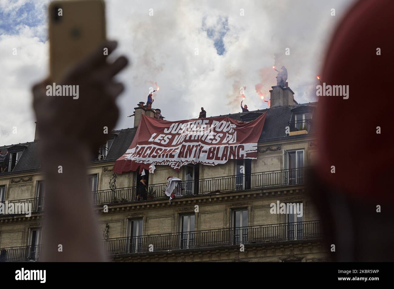 Le groupe d'extrême droite ''génération identitaire'' a essayé d'afficher une bannière dénonçant un soi-disant ''racisme anti-blanc'' lors de la manifestation contre le racisme et la violence policière organisée par le collectif ''Verite pour Adama'' sur 13 juin 2020 à Paris. Les résidents du bâtiment sur lequel cette action a eu lieu ont coupé la bannière eux-mêmes avec des ciseaux. (Photo par Adnan Farzat/NurPhoto) Banque D'Images