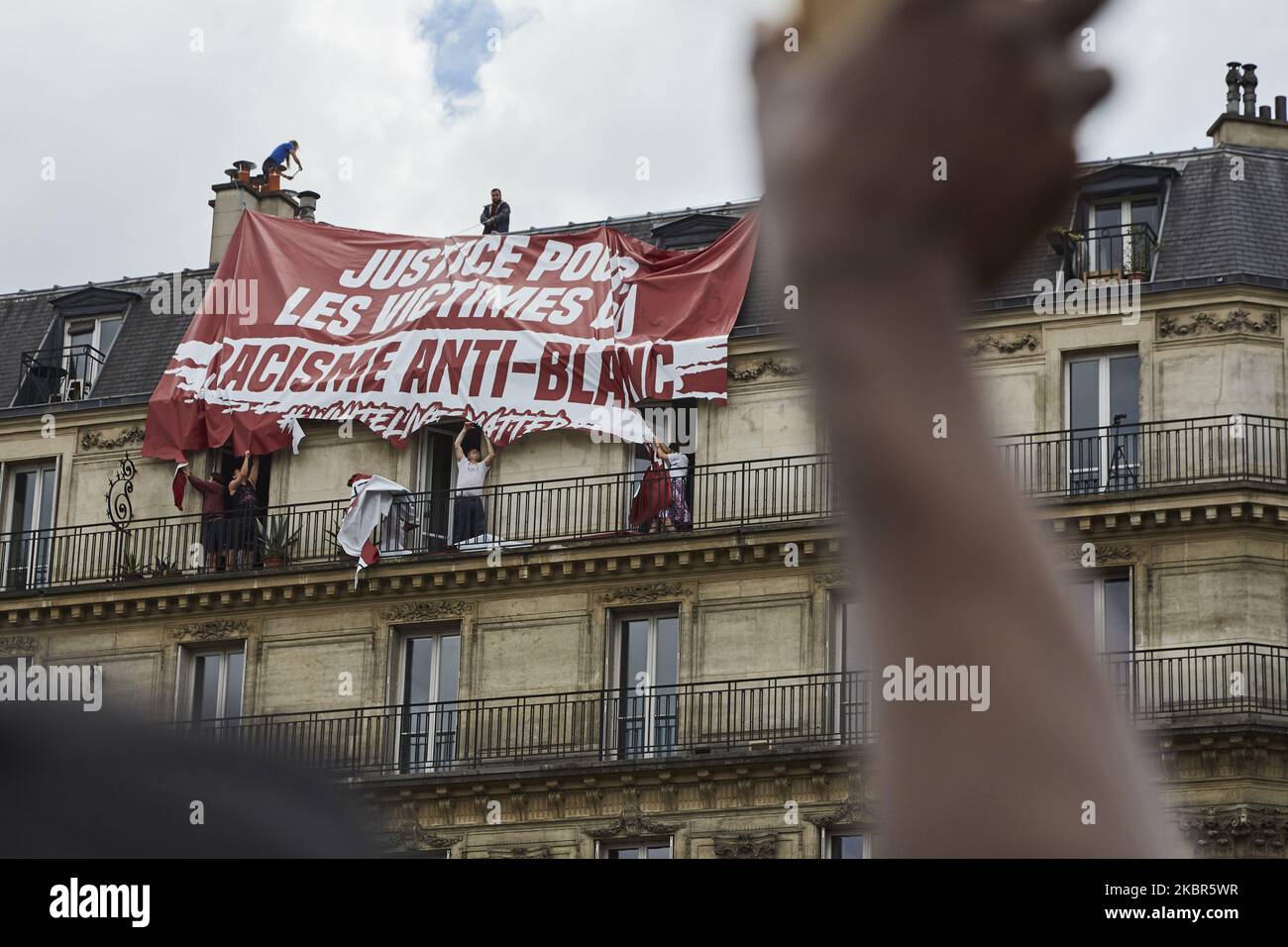 Le groupe d'extrême droite ''génération identitaire'' a essayé d'afficher une bannière dénonçant un soi-disant ''racisme anti-blanc'' lors de la manifestation contre le racisme et la violence policière organisée par le collectif ''Verite pour Adama'' sur 13 juin 2020 à Paris. Les résidents du bâtiment sur lequel cette action a eu lieu ont coupé la bannière eux-mêmes avec des ciseaux. (Photo par Adnan Farzat/NurPhoto) Banque D'Images