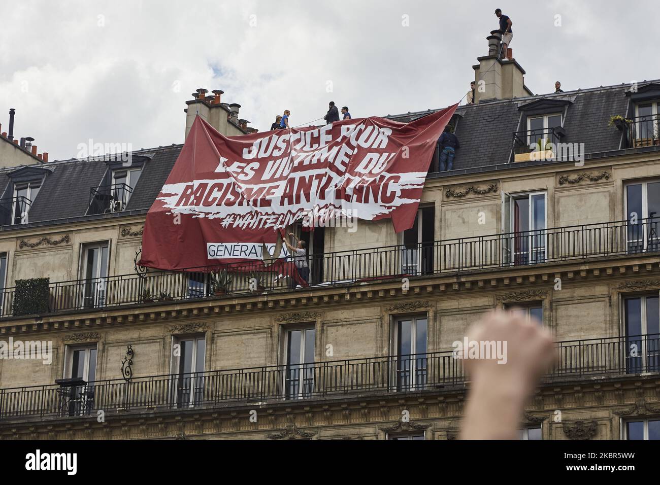 Le groupe d'extrême droite ''génération identitaire'' a essayé d'afficher une bannière dénonçant un soi-disant ''racisme anti-blanc'' lors de la manifestation contre le racisme et la violence policière organisée par le collectif ''Verite pour Adama'' sur 13 juin 2020 à Paris. Les résidents du bâtiment sur lequel cette action a eu lieu ont coupé la bannière eux-mêmes avec des ciseaux. (Photo par Adnan Farzat/NurPhoto) Banque D'Images