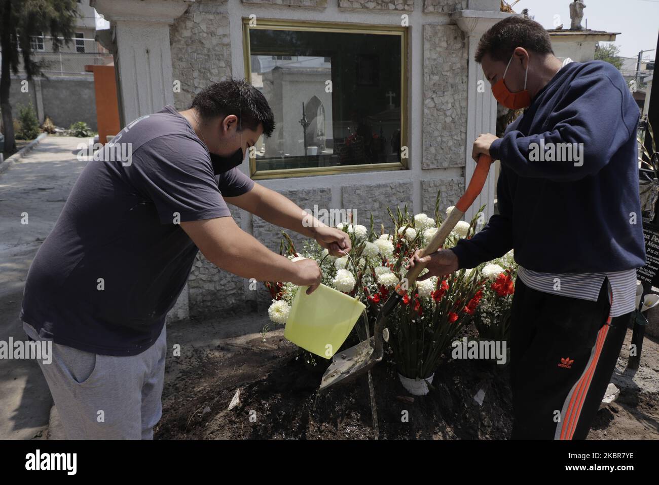 Les parents d'une personne décédée des soupçons de Covid-19, ont visité sa tombe dans le Panthéon de San Pedro Tláhuac, Mexico, pour placer une croix, des fleurs et de l'eau après avoir été enterré il y a quelques jours. Ils crièrent pour leur être aimé, prièrent quelques minutes, et quittèrent l'endroit, sur 15 juin 2020. (Photo de Gerardo Vieyra/NurPhoto) Banque D'Images