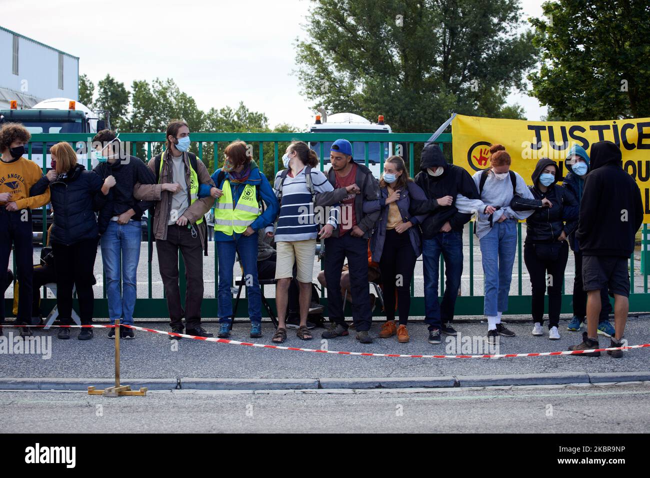 Les gens font une chaîne humaine devant l'usine de ciment Lafarge à Toulouse, en France, sur 17 juin 2020. Des membres et des activistes de l'ONG ANV-COP21 (c'est-à-dire non violent action-COP21) ont organisé une journée nationale de protestation contre le soi-disant 'vieux monde' et contre le 're-empoisonnement du monde' avec la réouverture de l'économie après le confinement de Covid-19. Ils veulent faire prendre conscience de l'empreinte carbone de la construction. À Toulouse, ils ont bloqué une installation de béton Lafarge pendant plusieurs heures. (Photo d'Alain Pitton/NurPhoto) Banque D'Images