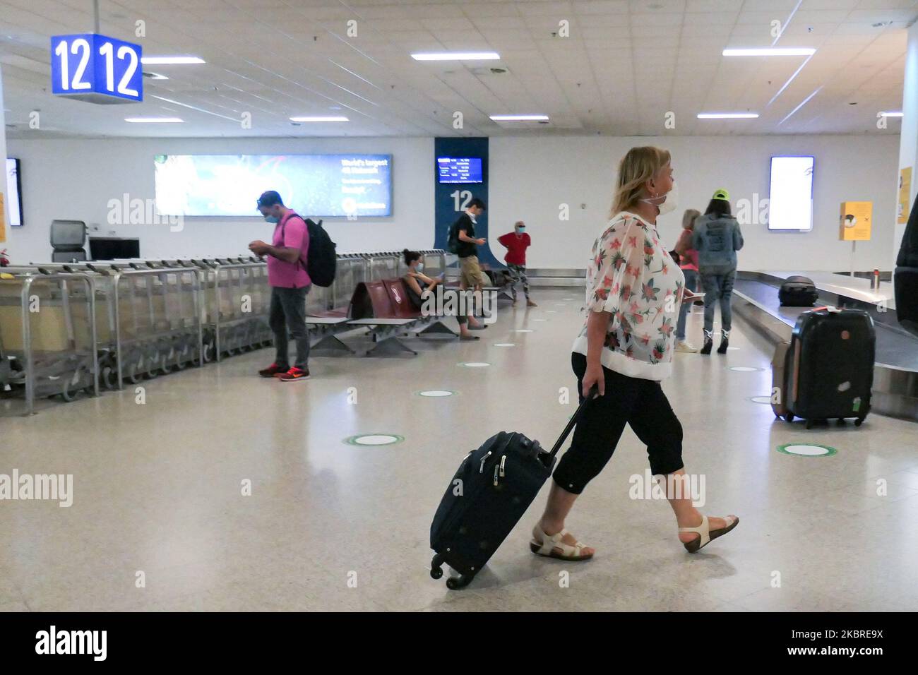 Passagers vus avec les masques obligatoires à l'aéroport international d'Athènes ATH LGAV à Athènes, Grèce sur 18 juin 2020, après la quarantaine de confinement du coronavirus et les restrictions de voyage. Les passagers portant des masques et des gants, utilisant des désinfectants pour les mains comme mesure préventive contre la propagation de la pandémie COVID-19. La Grèce et l'Europe ont fermé les frontières des personnes en dehors de l'Europe et de la zone Schengen pendant longtemps, mais la Grèce a commencé à lever l'interdiction de circulation depuis 15 juin 2020 pour les pays de la zone Schengen et l'1 juillet 2020 aura davantage d'assouplissement. Les passagers arrivant sont soumis à des Banque D'Images
