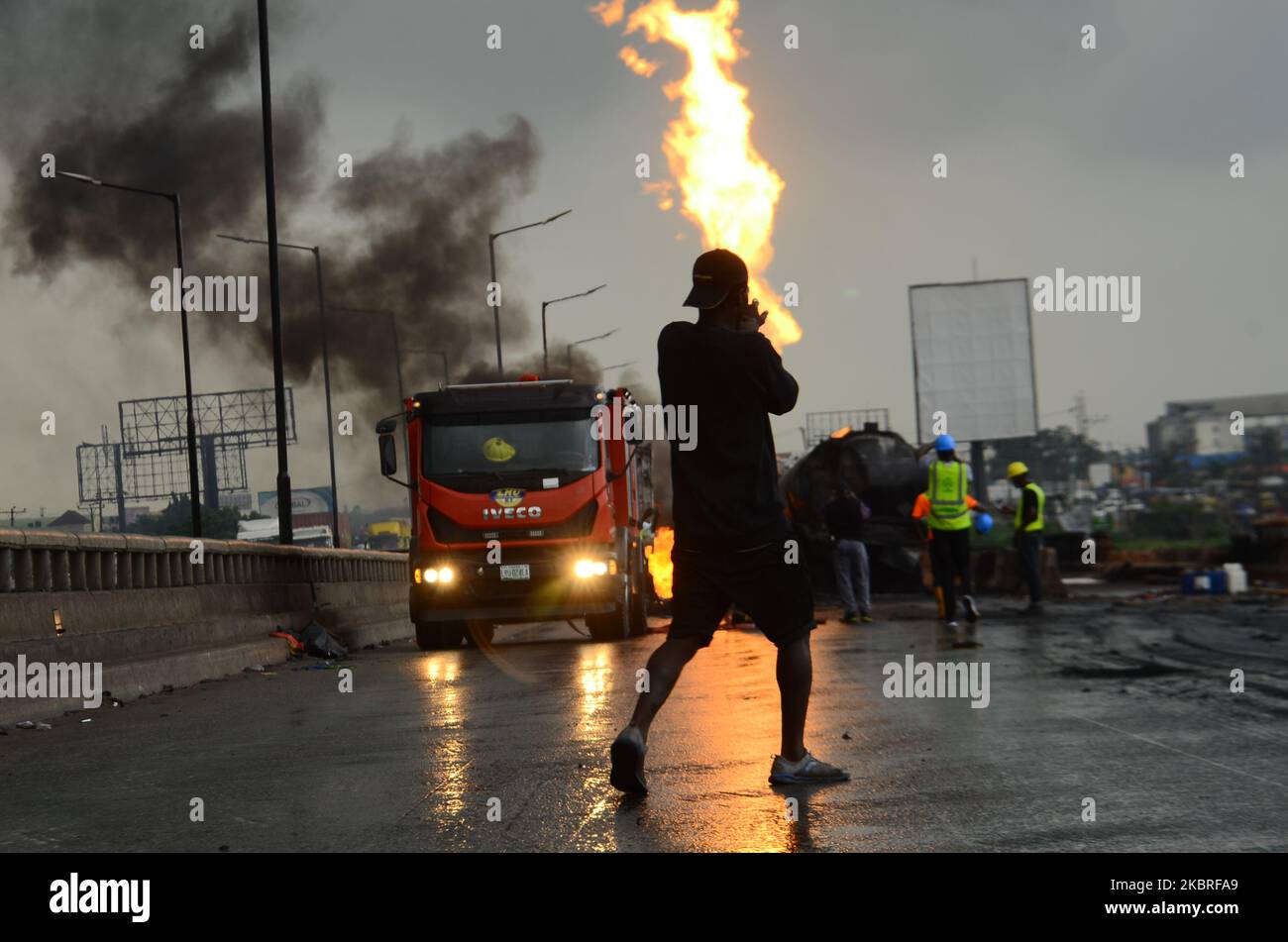 Un homme à pied passe devant un feu brûlant lors d'une explosion de camion-citerne impliquant quatre véhicules articulés sur la section du pont de Kara de l'autoroute Lagos-Ibadan sur 21 juin 2020. (Photo par Olukayode Jaiyeola/NurPhoto) Banque D'Images