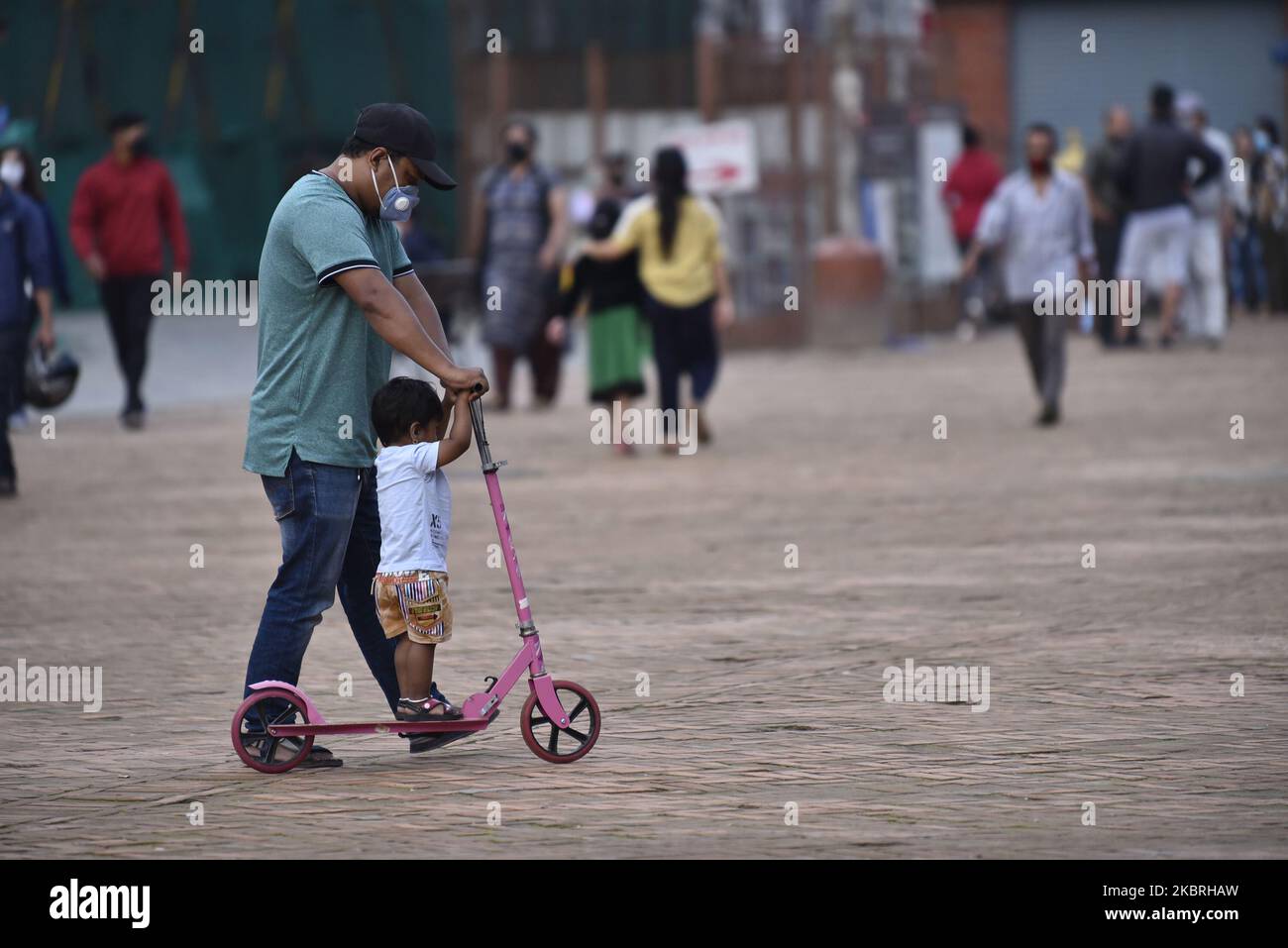 Un Père apprend comment faire monter des enfants à deux roues Scooter à son enfant dans les locaux de Basantapur Durbar Square pendant le confinement partiel en cours dans tout le pays comme préoccupations au sujet de la propagation du virus Corona (COVID-19) à Katmandou, Népal mardi, 23 juin 2020. (Photo de Narayan Maharajan/NurPhoto) Banque D'Images