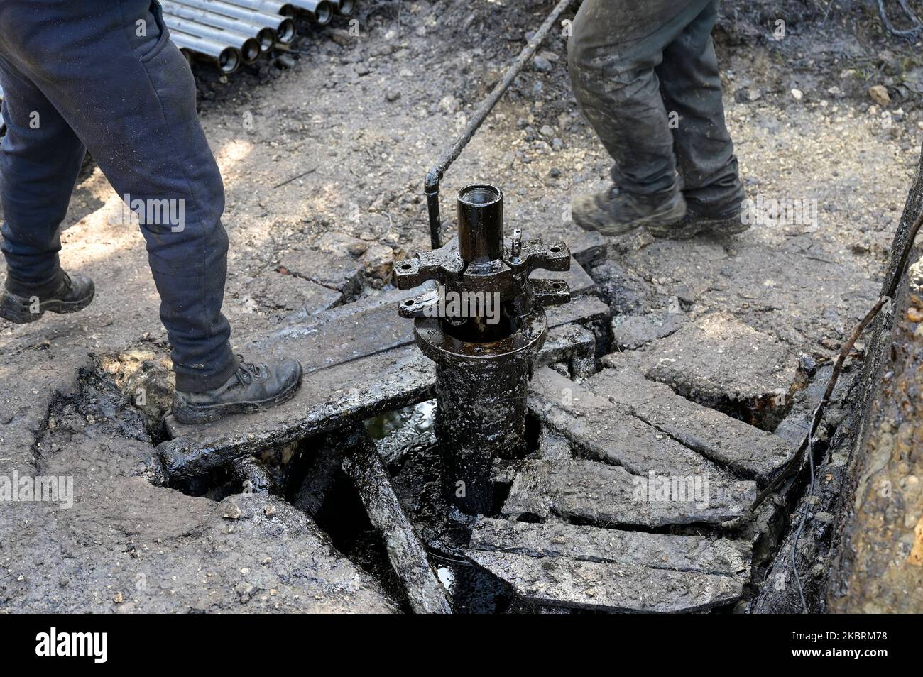 ALBANIE, Kuçova, nommé ville de Staline à partir de 1950 to1991, champ de pétrole brut et pompe de forage de l'ère communiste, toujours en fonctionnement et polluant l'environnement, ouvrier avec le tuyau de forage / ALBANIEN, Kucova, von 1950 bis 1991 Qyteti Staline, Stalinstadt, Erdoelfoerderung, alte Oelfoerderpe, die heute noch pumzur, Özörsind, Betrieb pumzur Beiter mit Bohrgestänge Banque D'Images