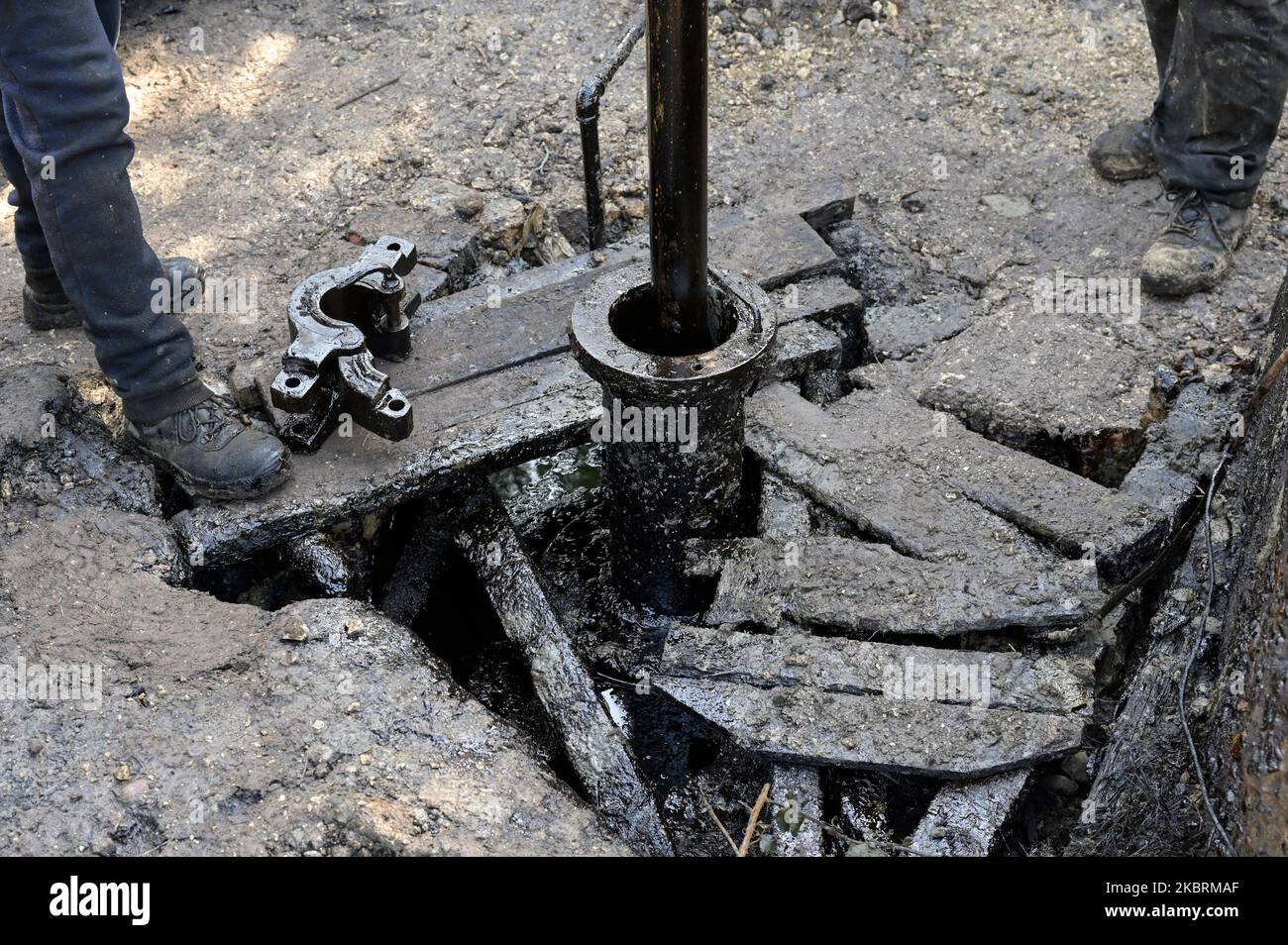 ALBANIE, Kuçova, nommé ville de Staline à partir de 1950 to1991, champ de pétrole brut et pompe de forage de l'ère communiste, toujours en fonctionnement et polluant l'environnement, ouvrier avec le tuyau de forage / ALBANIEN, Kucova, von 1950 bis 1991 Qyteti Staline, Stalinstadt, Erdoelfoerderung, alte Oelfoerderpe, die heute noch pumzur, Özörsind, Betrieb pumzur Beiter mit Bohrgestänge Banque D'Images