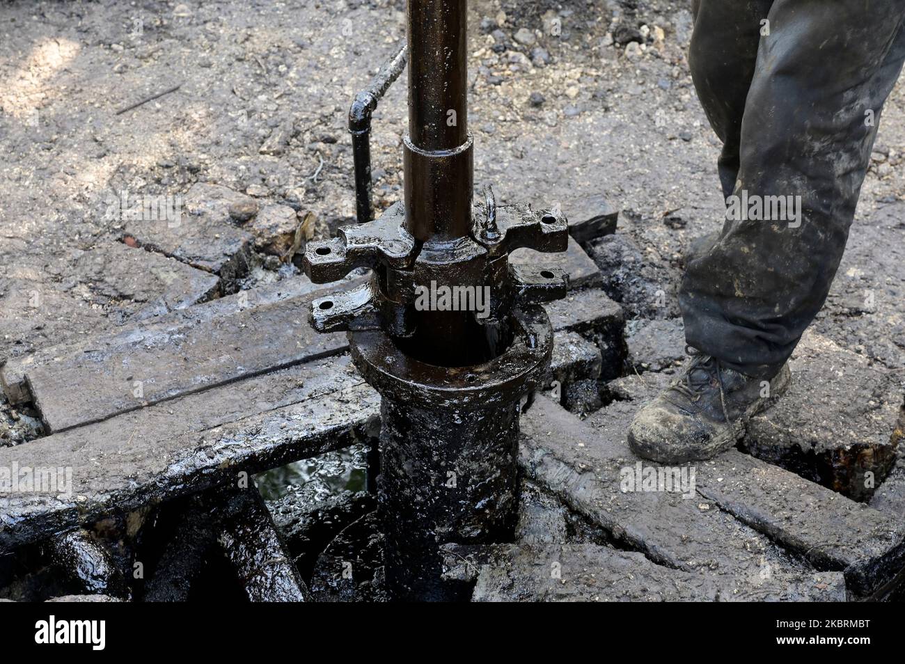 ALBANIE, Kuçova, nommé ville de Staline à partir de 1950 to1991, champ de pétrole brut et pompe de forage de l'ère communiste, toujours en fonctionnement et polluant l'environnement, ouvrier avec le tuyau de forage / ALBANIEN, Kucova, von 1950 bis 1991 Qyteti Staline, Stalinstadt, Erdoelfoerderung, alte Oelfoerderpe, die heute noch pumzur, Özörsind, Betrieb pumzur Beiter mit Bohrgestänge Banque D'Images