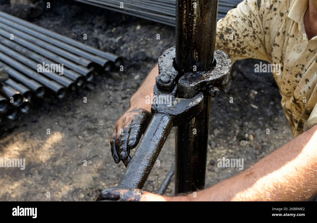 ALBANIE, Kuçova, nommé ville de Staline à partir de 1950 to1991, champ de pétrole brut et pompe de forage de l'ère communiste, toujours en fonctionnement et polluant l'environnement, ouvrier avec le tuyau de forage / ALBANIEN, Kucova, von 1950 bis 1991 Qyteti Staline, Stalinstadt, Erdoelfoerderung, alte Oelfoerderpe, die heute noch pumzur, Özörsind, Betrieb pumzur Beiter mit Bohrgestänge Banque D'Images