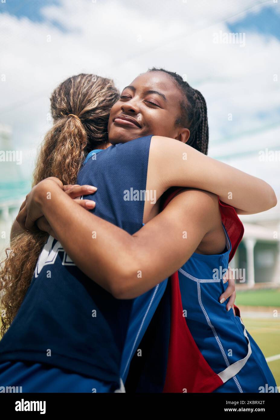 Sports, hug et les femmes amis avec le travail d'équipe, le soutien et l'amour pour le jeu, la compétition et la réussite de l'entraînement dans un champ de parc. Netball, collaboration et Banque D'Images