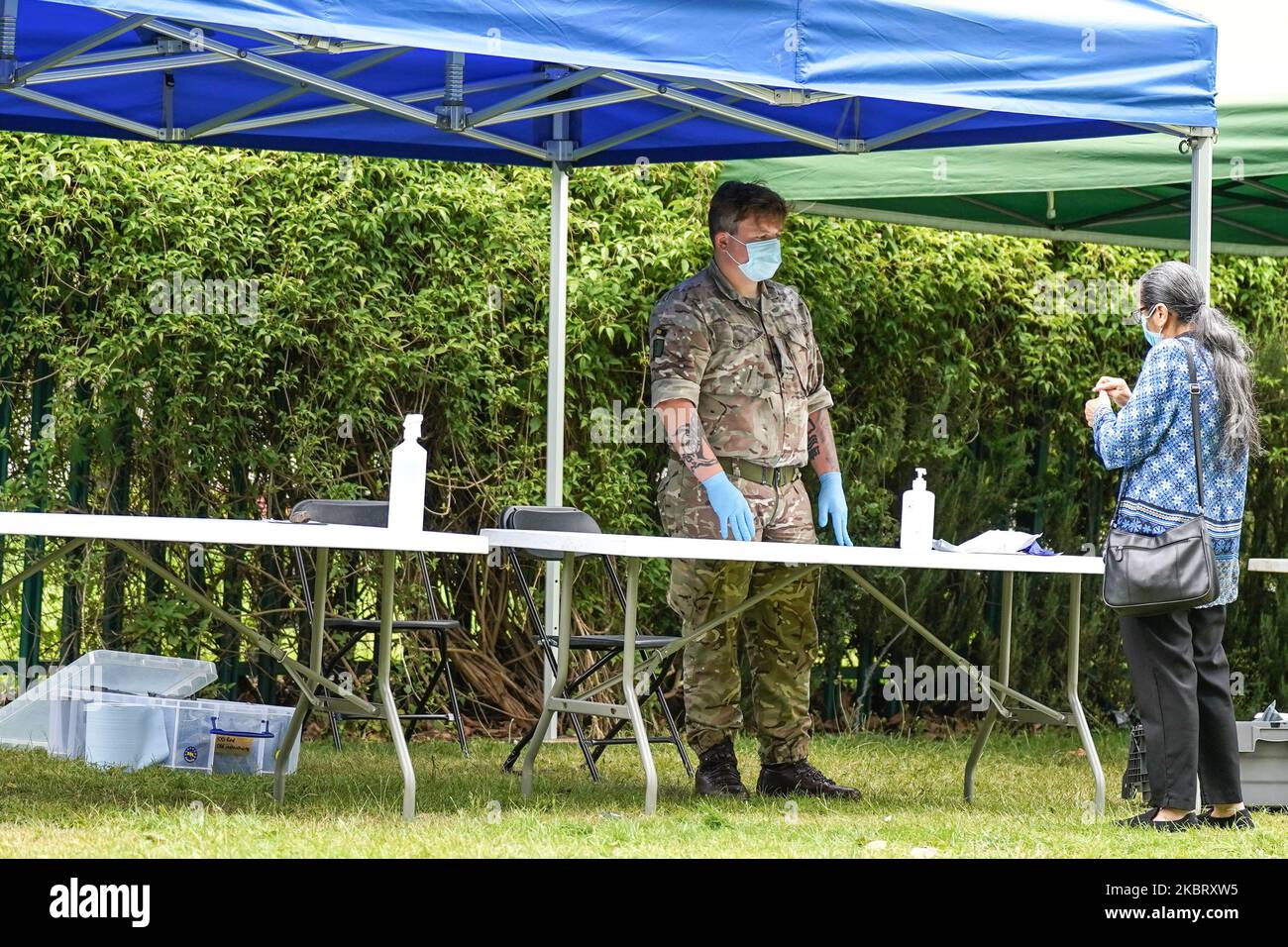 Un membre des forces armées regarde comme des membres d'une famille administrer un auto-test à une station établie pour le test du nouveau coronavirus COVID-19, dans le parc Spinney Hill à Leicester, où plusieurs cas de coronavirus ont été détectés. (Photo de Giannis Alexopoulos/NurPhoto) Banque D'Images