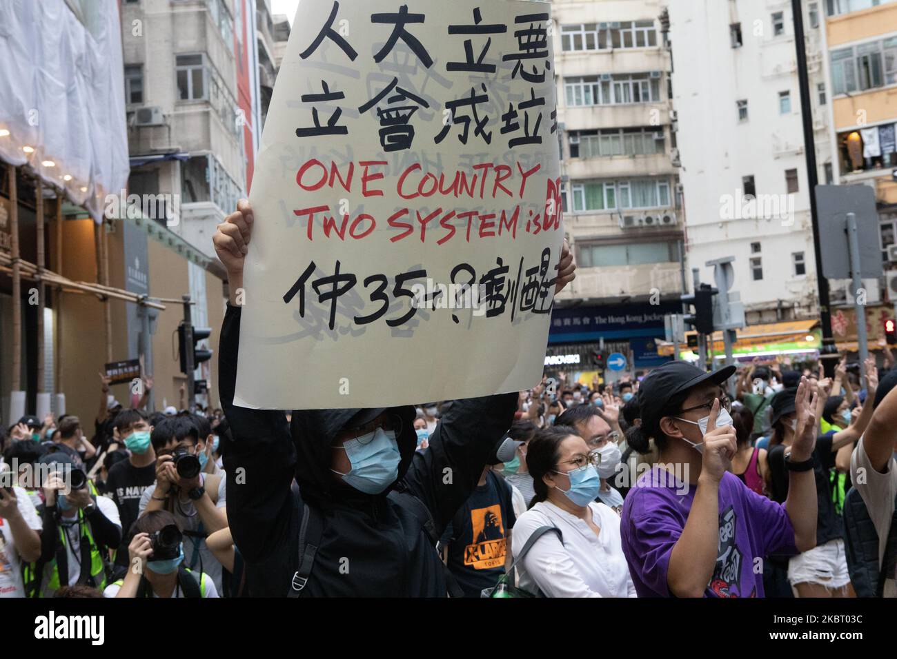 Les manifestants tiennent un panneau « un pays, deux systèmes sont morts » tout en couvrant leur visage en raison de la loi sur la sécurité nationale qui vient d'être introduite lors des manifestations à l'occasion de l'anniversaire de la remise de Hong Kong en Chine, dans le cadre de la nouvelle loi sur la sécurité sur 1 juillet 2020 à Hong Kong, en Chine. (Photo de Simon Jankowski/NurPhoto) Banque D'Images