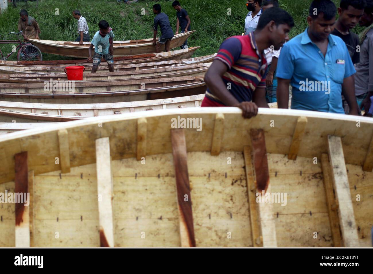 Les gens se rassemblent sur un marché hebdomadaire pour acheter un bateau en bois à Manikganj, Dhaka, Bangladesh, le samedi, 04 juillet,2020. Pendant la saison des pluies, les gens du Bangladesh avaient besoin d'un bateau pour se déplacer dans les endroits les plus proches, car les eaux d'inondation submergent le chemin du voyage. (Photo de Syed Mahamudur Rahman/NurPhoto) Banque D'Images