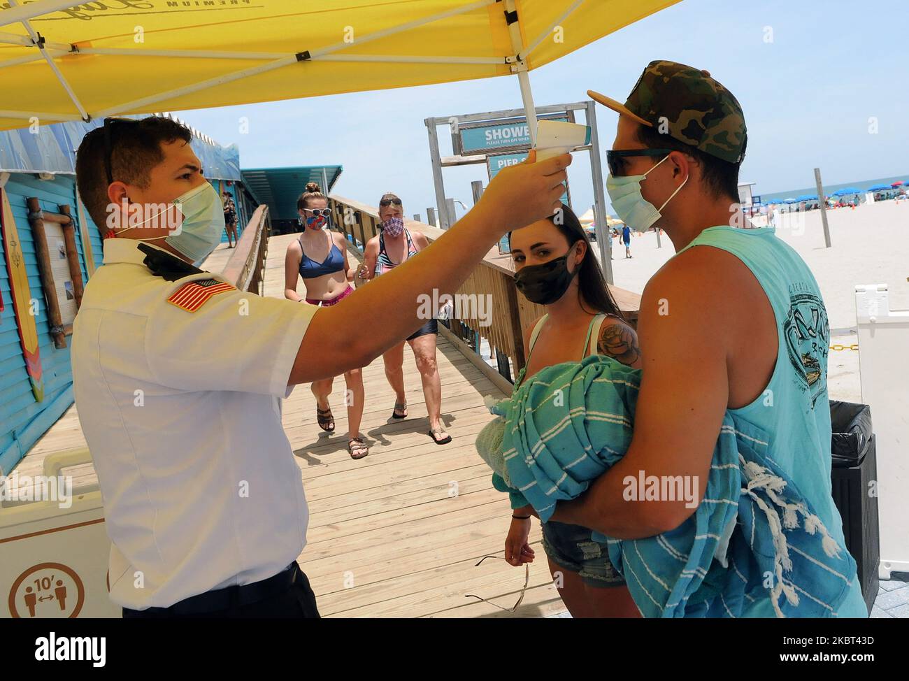 Les gens portent un masque facial et subissent des contrôles de température obligatoires avant d'entrer dans la jetée le jour de l'indépendance, 4 juillet 2020, à Cocoa Beach, Floride. Les foules à la plage étaient en dessous de la normale pour un week-end de vacances en raison de la pandémie du coronavirus et d'une augmentation des cas de COVID-19 en Floride. (Photo de Paul Hennessy/NurPhoto) Banque D'Images