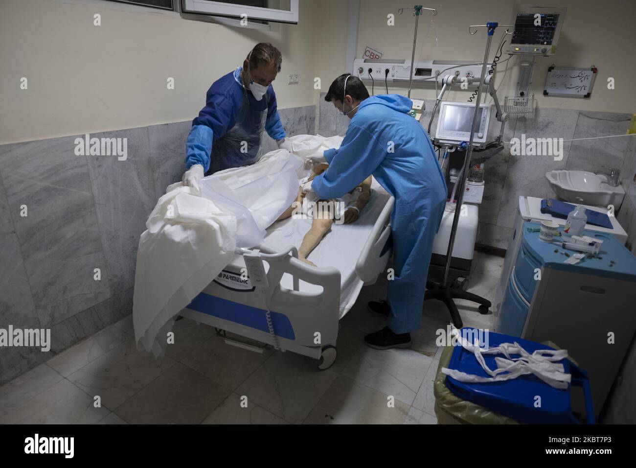 Deux membres du personnel de l'hôpital iranien portant une combinaison protectrice préparent un corps d'un afghan décédé de la nouvelle coronavirus pour se rendre à la morgue, dans une section COVID-19 de l'hôpital de Firoozabadi, dans le quartier de Shahre-Rey, dans le sud de Téhéran, à minuit, sur 20 juin 2020. (Photo de Morteza Nikoubazl/NurPhoto) Banque D'Images