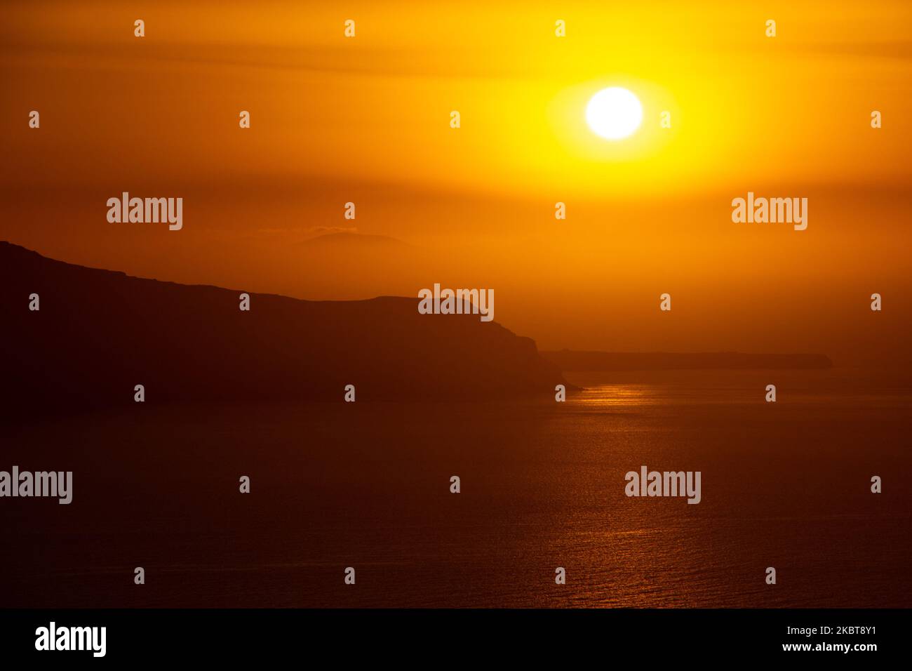 Vue sur le coucher du soleil depuis Thera sur l'île de Santorin, Cyclades dans la mer Egée en Grèce. Quelques touristes et les habitants apprécient le coucher de soleil magique sur le volcan à Fira alors que le pays a ouvert les aéroports et a permis aux touristes de venir après 1 juillet en raison de la pandémie du coronavirus Covid-19 mesures générales de confinement qui ont commencé à se relâcher depuis 15 juin. La Grèce a récemment rouvert la saison d'été du tourisme avec le Premier ministre Kyriakos Mitsotakis ayant un discours de Santorin pendant le coucher du soleil pour relancer la saison touristique car l'économie grecque est fortement basée sur elle. Juillet 2020 (photo de Nicolas Economou/ Banque D'Images